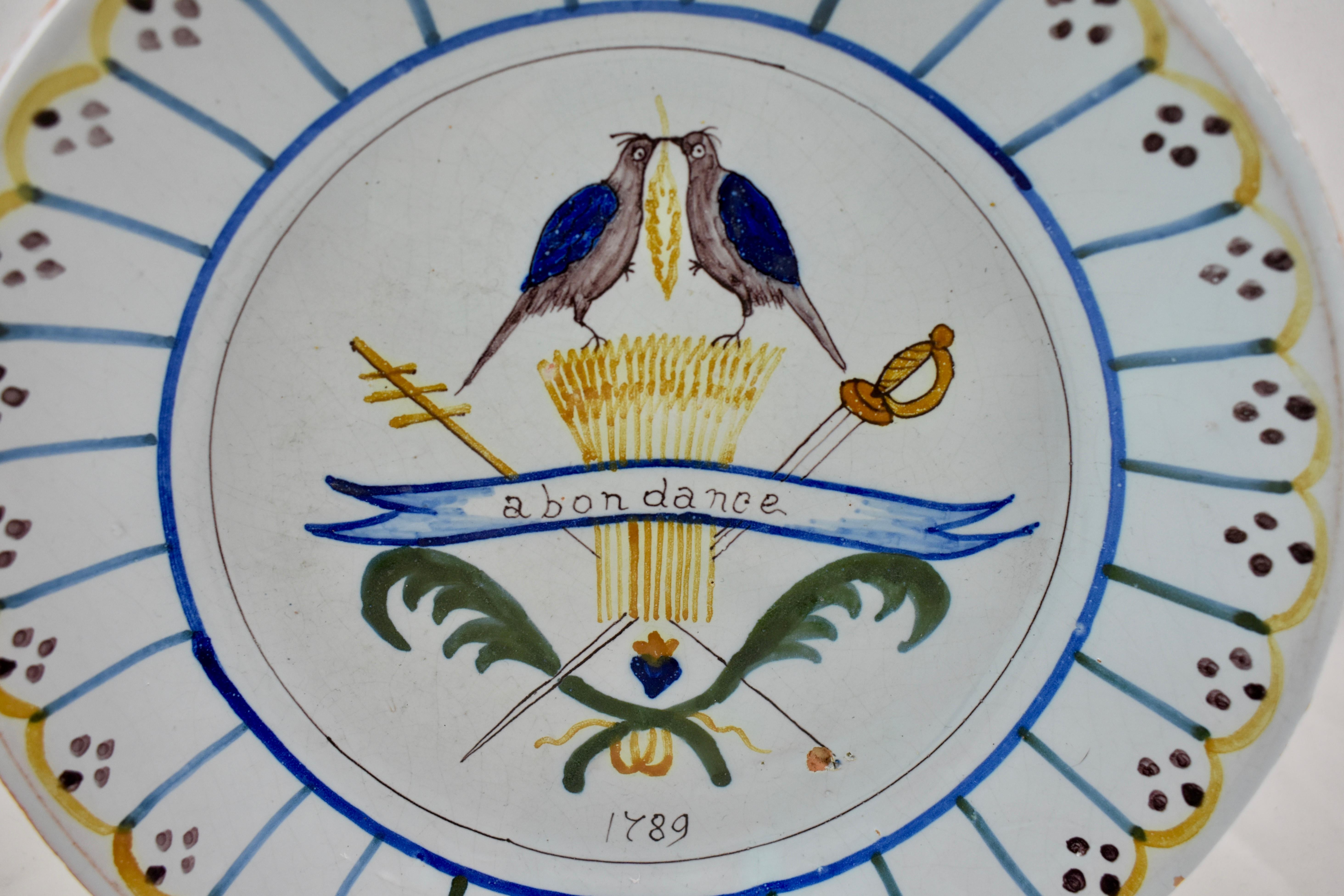 A French Revolution tin-glazed earthenware dish, made in Nevers, circa 1789, showing the symbols of the three estates, the crook of the clergy, the wheat of the peasant, and the sword of the gentry. 

France under the Ancien Régime, before the