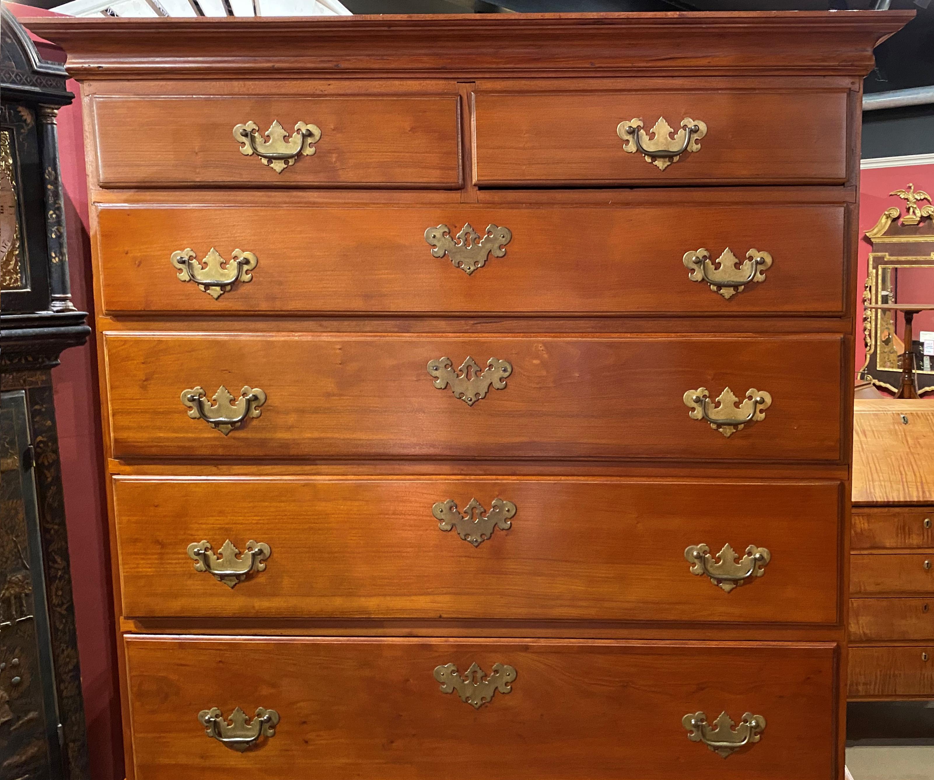 A fine two part married cherry highboy in cherry with a molded cornice surmounting an upper case with two over four graduated drawer configuration, and an associated lower case with replaced waist molding and a two over three drawer configuration,