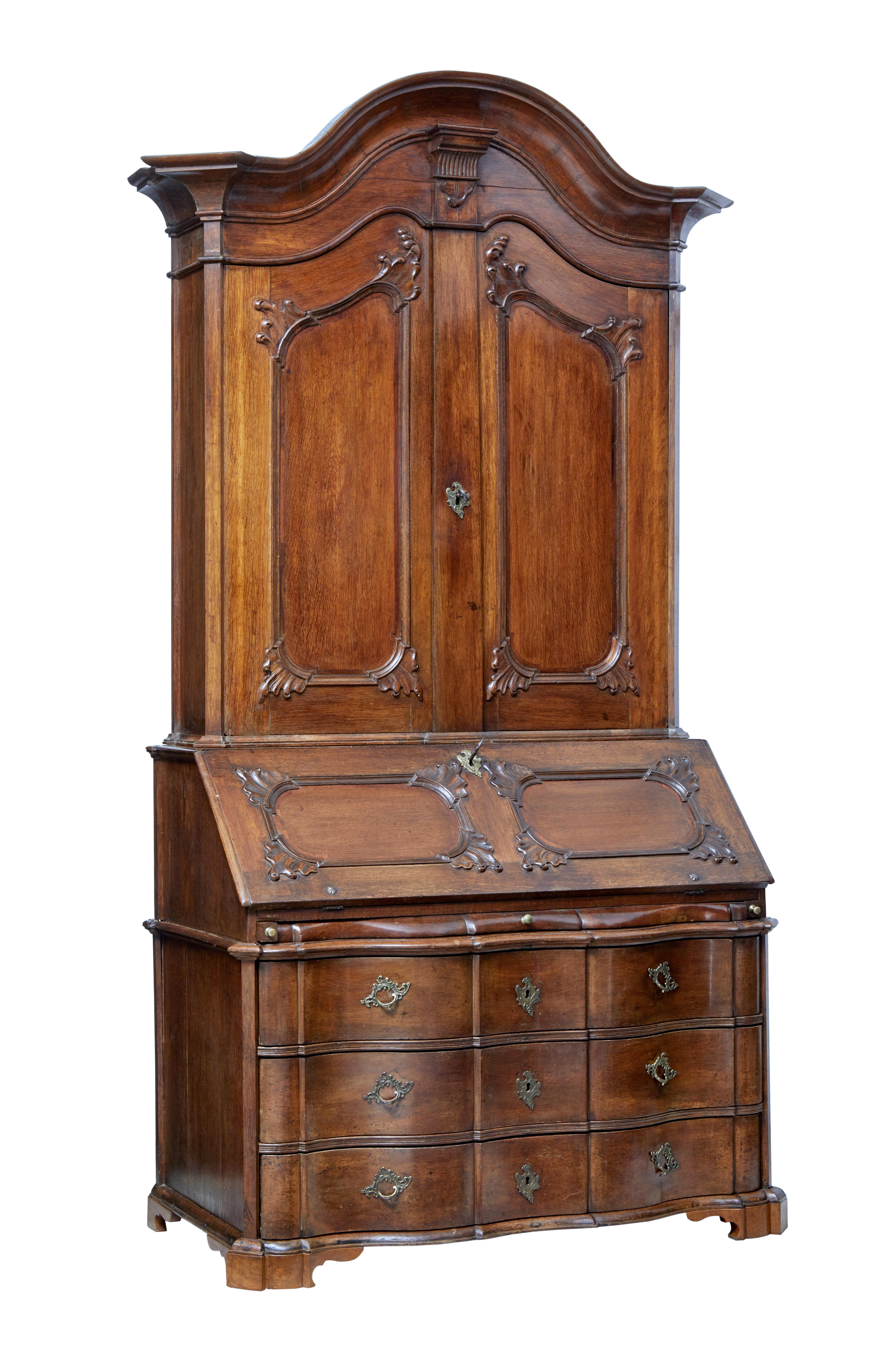 Stunning and rare Norwegian baroque oak bureau bookcase, circa 1760.

Comprising of three sections due to the monumental proportions.

Top section with shaped cornice, below which the carved double doors open to five shelves and four fitted