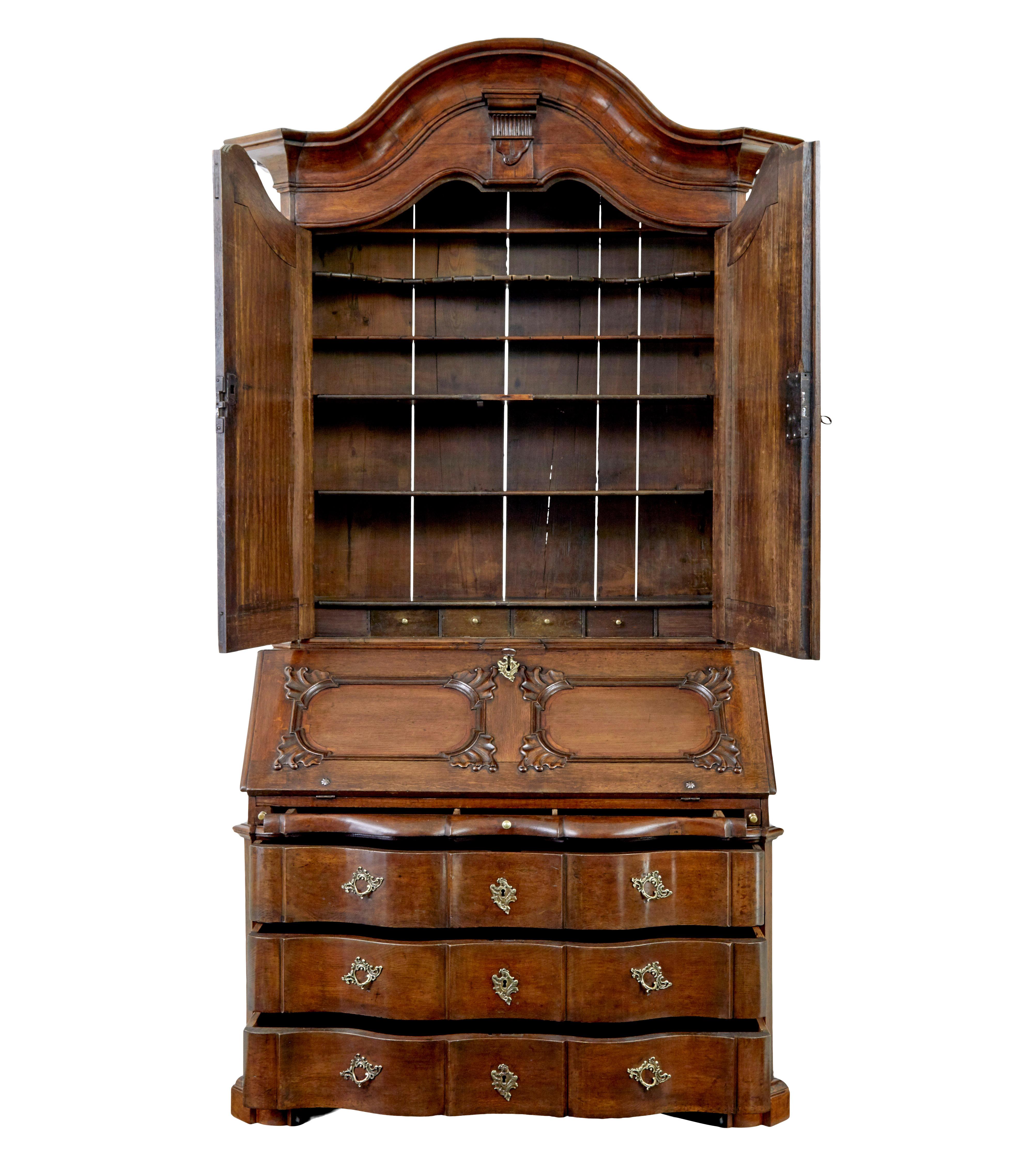 Étonnante et rare bibliothèque-bureau en chêne baroque norvégien vers 1760.

Composé de 3 sections en raison de ses proportions monumentales.

Partie supérieure avec corniche façonnée, sous laquelle les doubles portes sculptées s'ouvrent sur 5