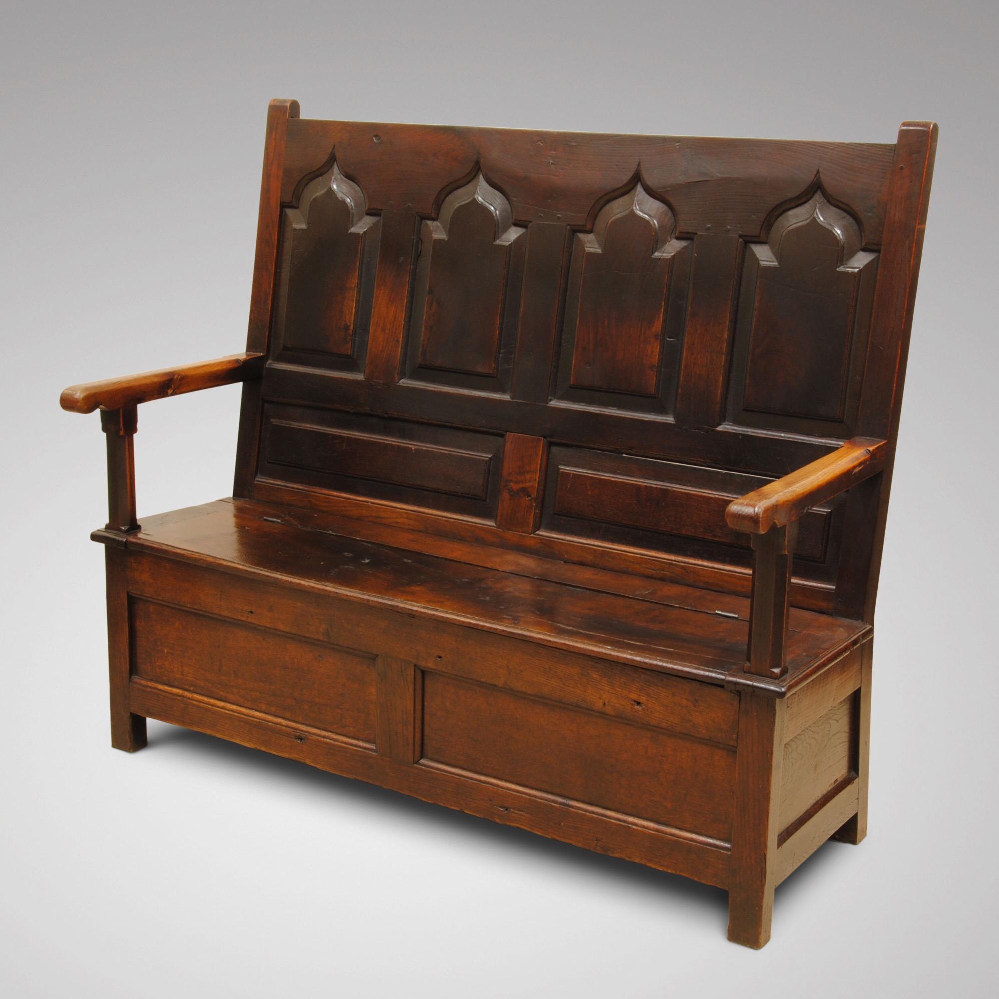 A fine example of an 18th century oak box settle with Gothic fielded panels to the back, wonderful rich color and patina.
  