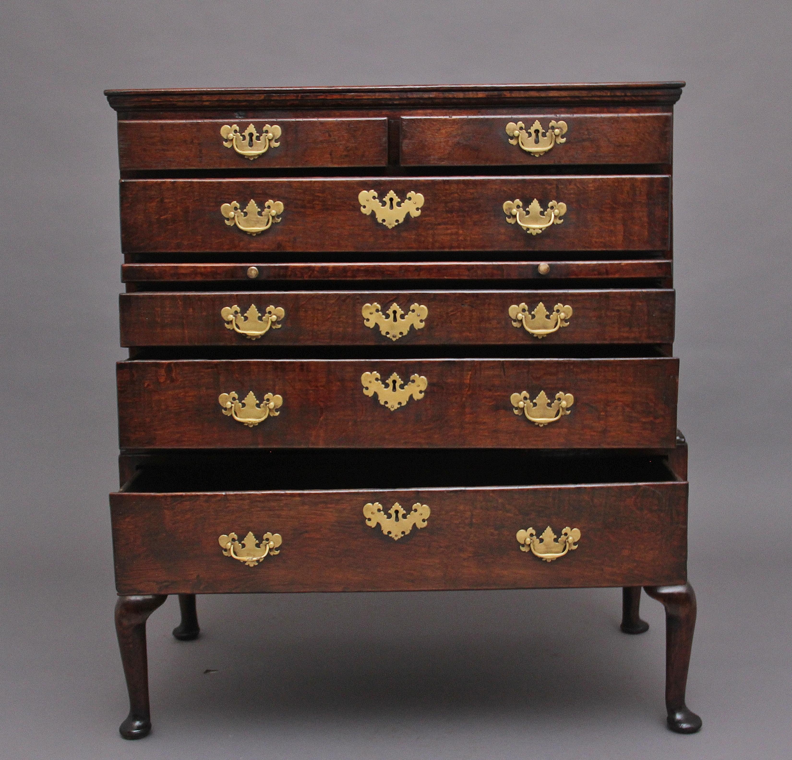 A fabulous quality 18th Century oak chest on stand, the moulded edge cornice above two short over four long graduated drawers with brass plate handles and escutcheons, with a pull out brushing slide at the centre, the base section having a nicely