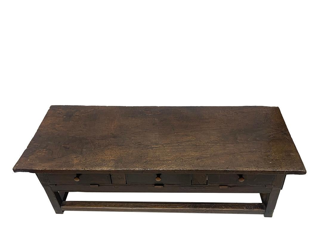 18th Century oak coffee table

A coffee table made of oak top with straight legs united with straight stretchers. 
There are three drawers on one side.
The oak wooden sides inside of one of the drawers are glued. 
An European piece of furniture with