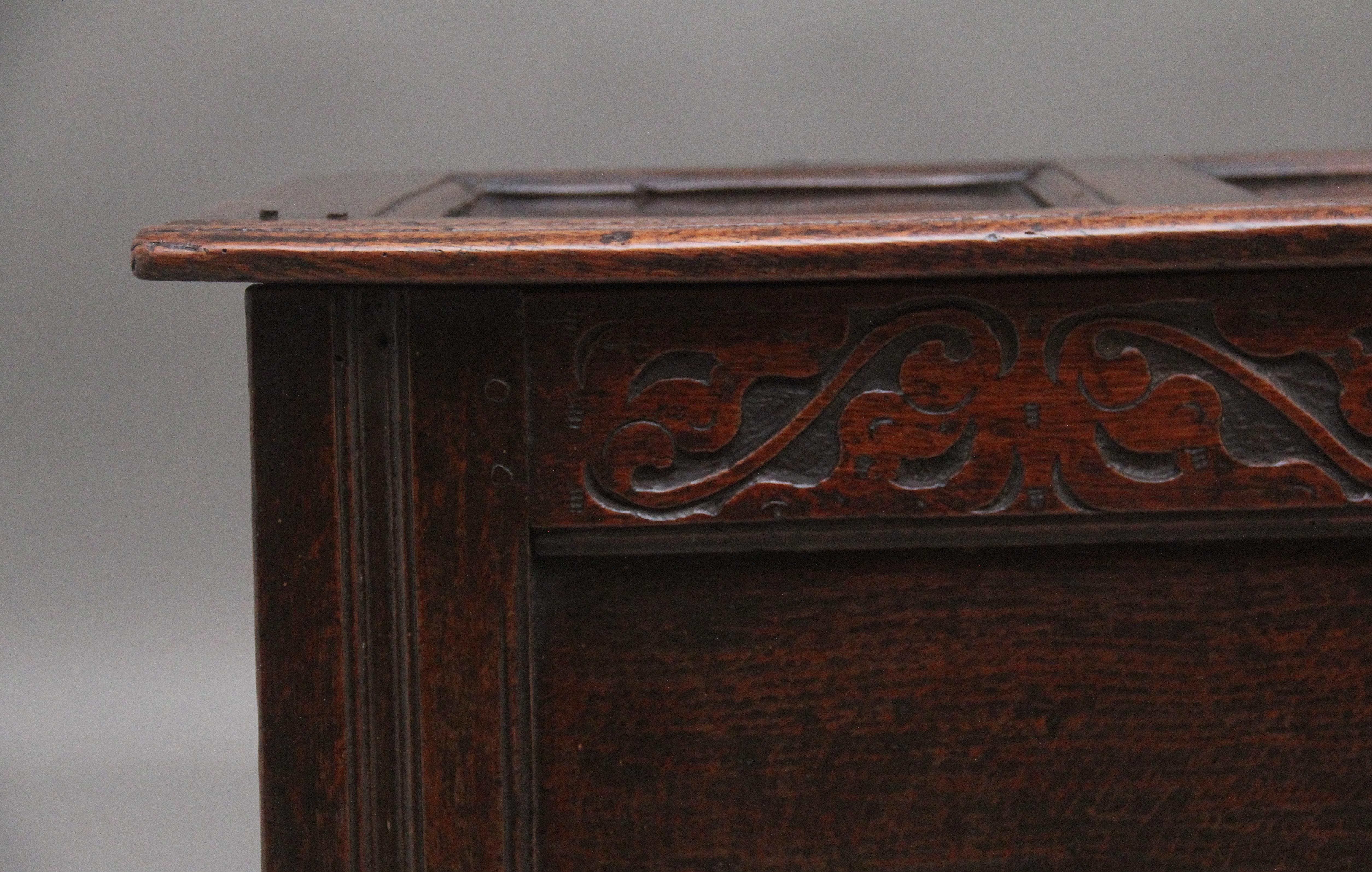 Eichenholzkassette aus dem 18. Jahrhundert, deren dreifach getäfelter Deckel mit Scharnieren geöffnet werden kann, um ein großes Fach freizugeben. Die zweifach getäfelte Vorderseite hat wunderschöne dekorative Schnitzereien, die Seiten sind getäfelt