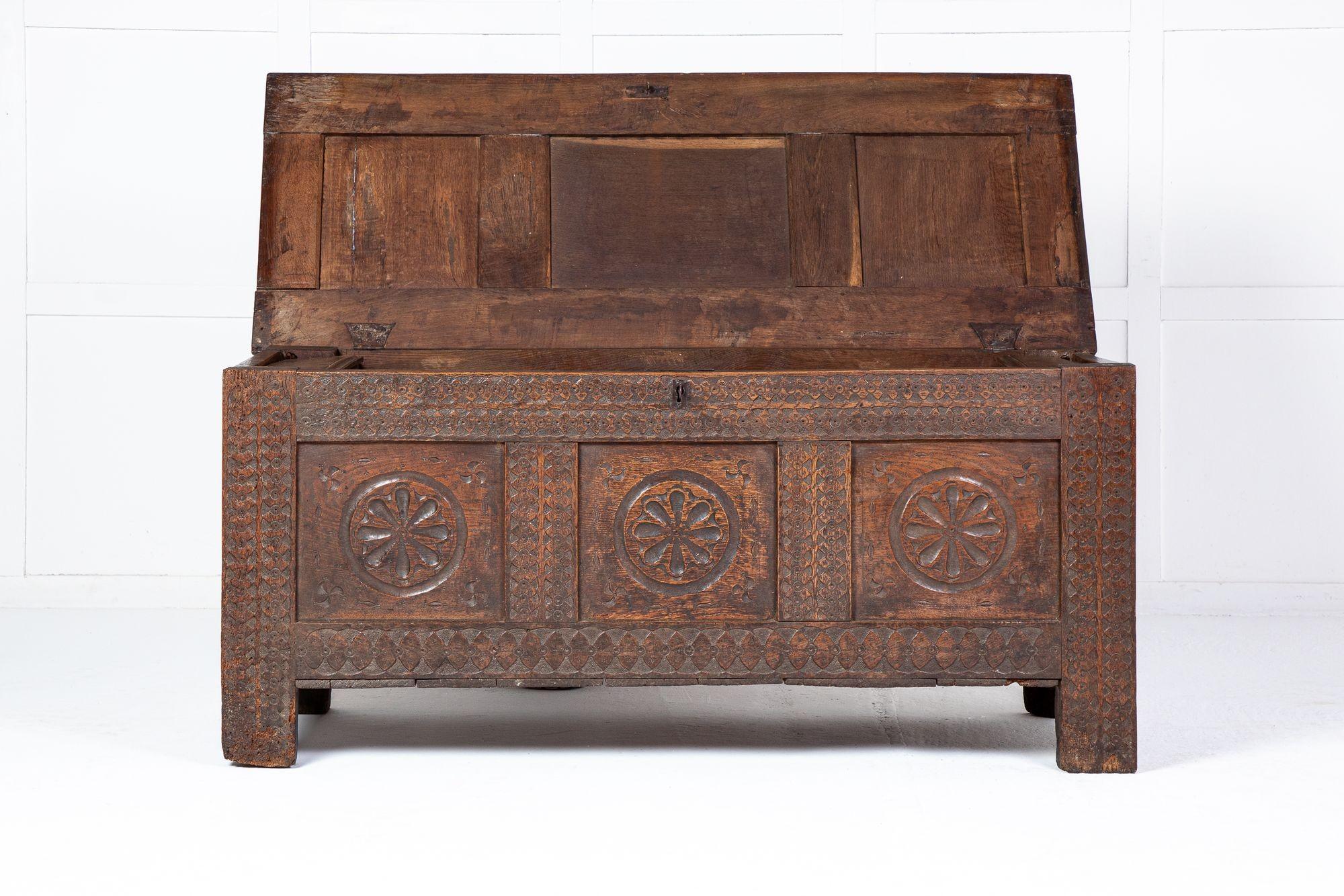 A nice style, 18th century oak coffer. Having three fielded panels to the top with moulded edge, above three carved panels to the front. The hinged lid opens to reveal a small boxed compartment. There is a lock and key. The front has three heavily