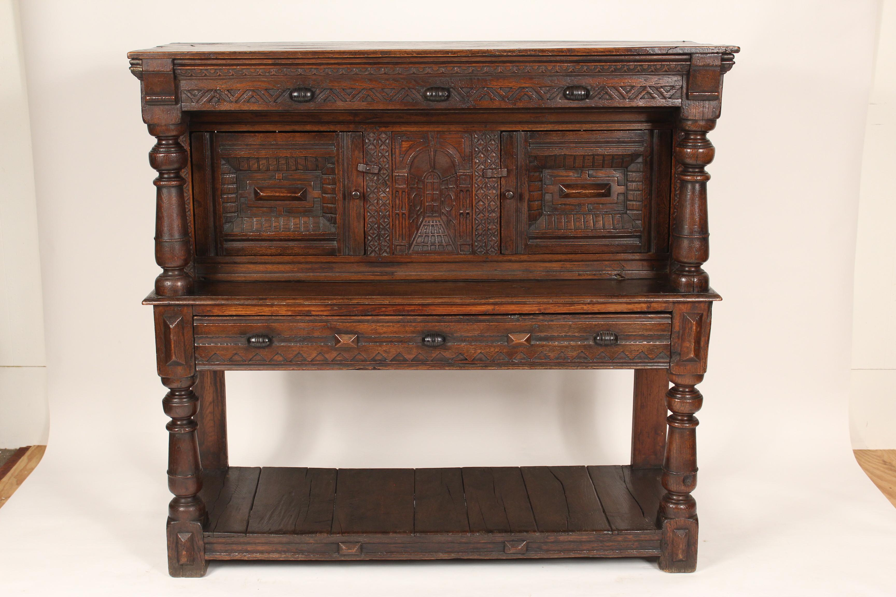 18th century oak court cupboard. With interesting carved central stationary panel flanked by two carved doors. Provenance: Probably Carl Yeakel Antiques, Laguna Beach.