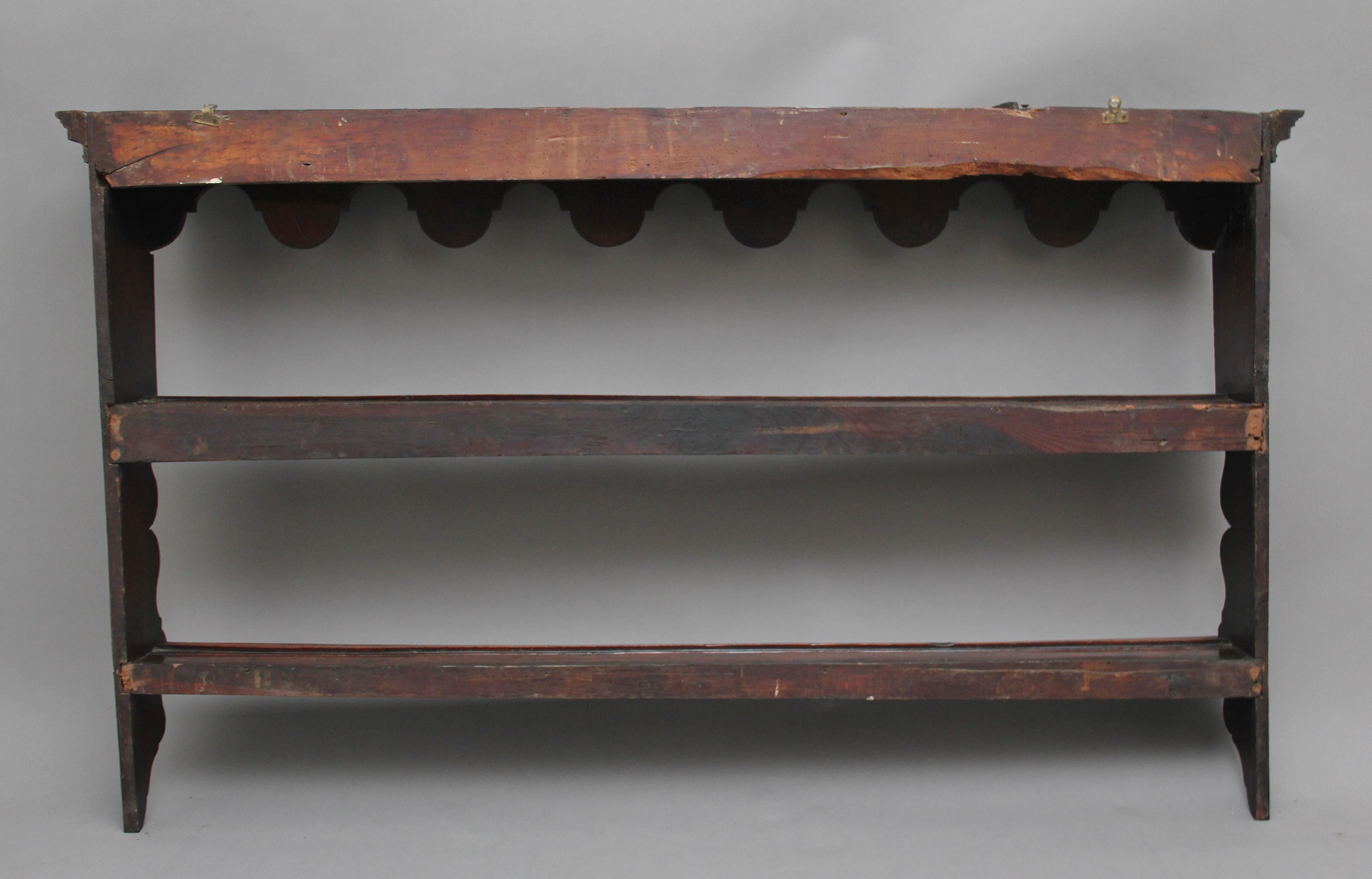 18th century oak hanging plate rack with two shelves and a shaped top and sides, circa 1780.