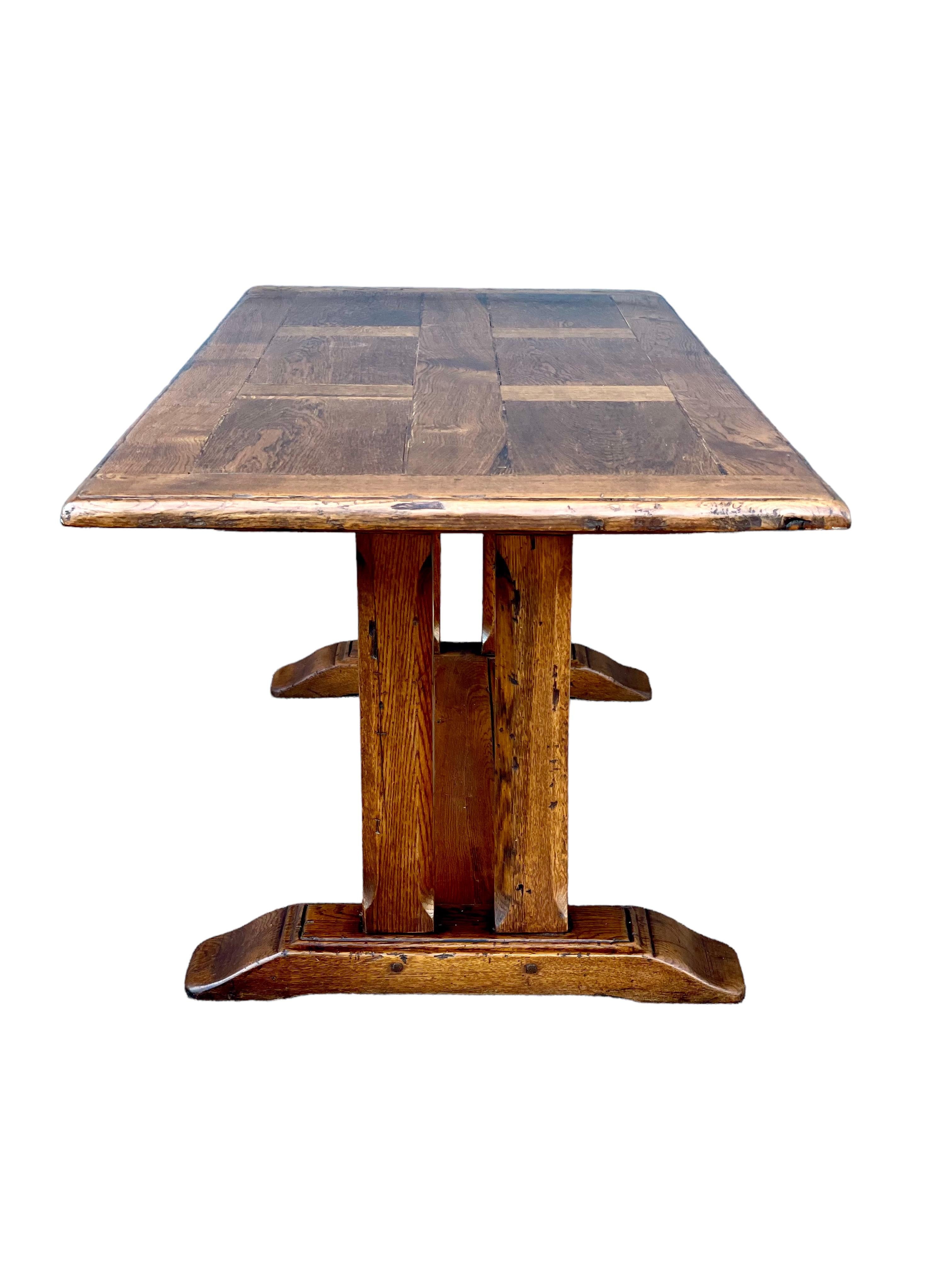 A substantial and very handsome monastery refectory table meticulously crafted from solid oak, and featuring the traditional trestle underframe and stretcher. The Louis XIII style table has a wonderful, authentic patina, gained from generations of