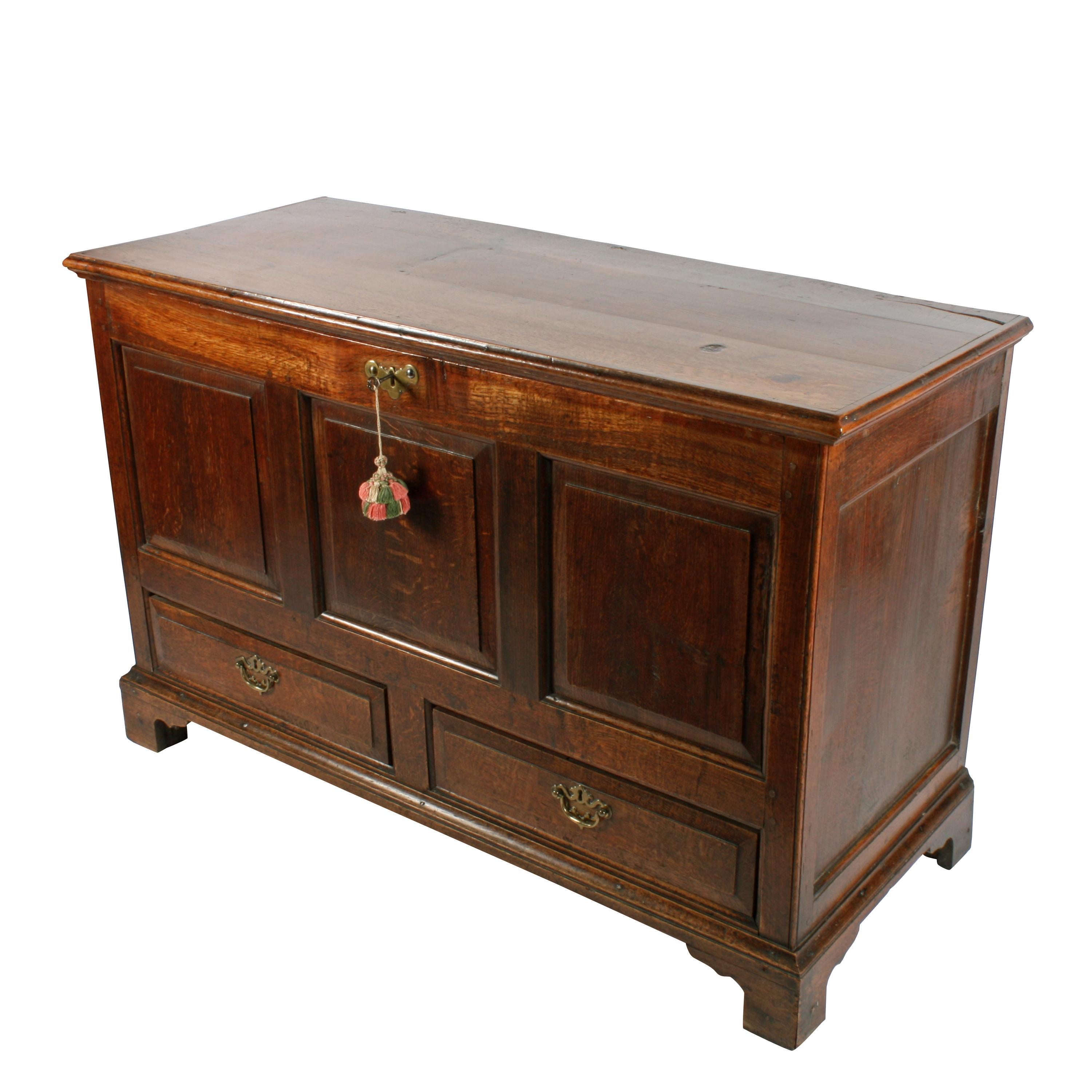 An 18th century George II oak mule or dower chest.

The chest has a hinged lid, three recessed fielded panels to the front and two drawers with fielded fronts to match.

The drawers are oak lined and have original brass handles and steel