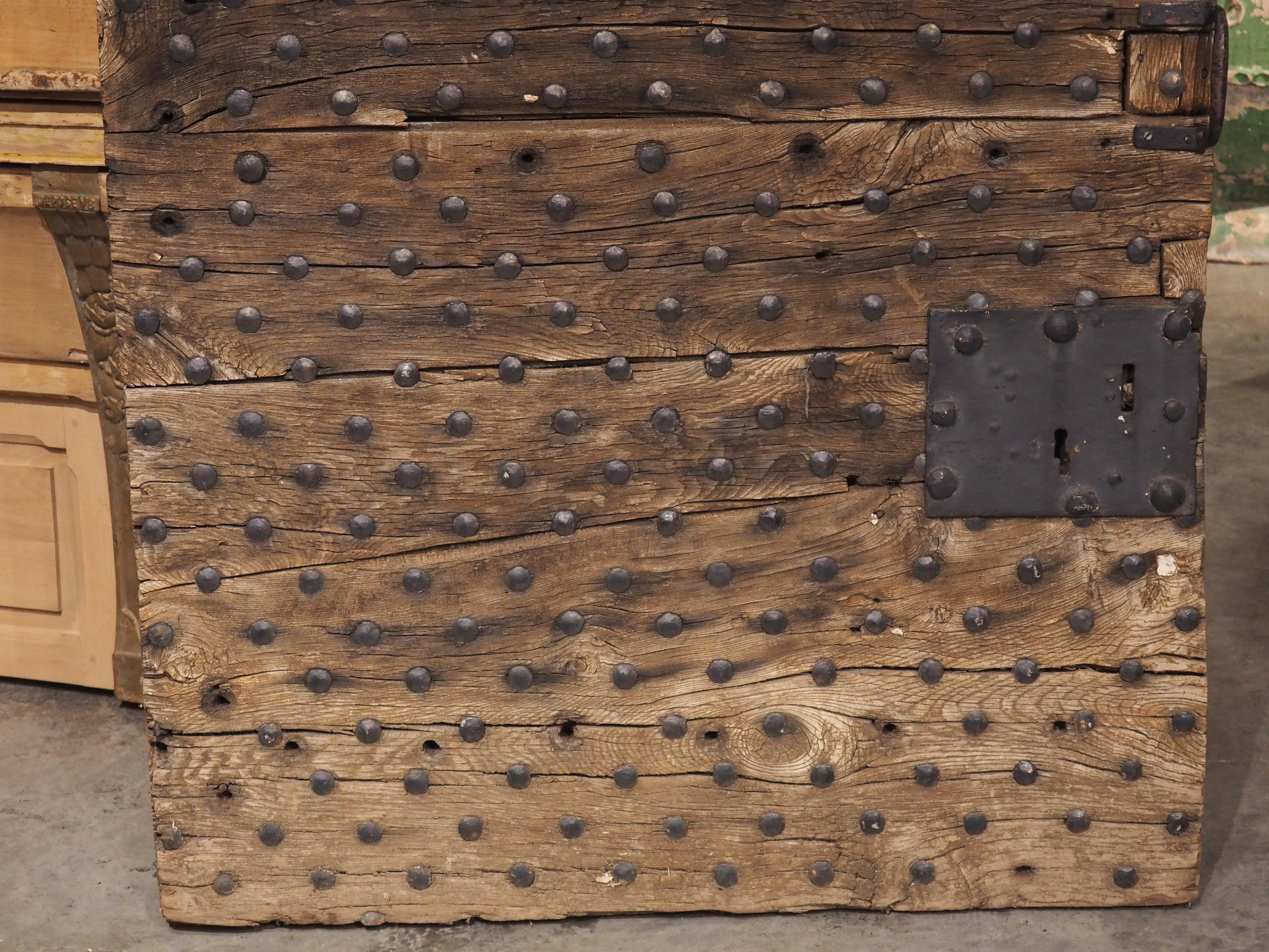 Taken from a prison in Romans-Sur-Isere, France, this porte cachot (dungeon door) has an exterior façade that is embellished with hundreds of iron nailheads arranged in 32 rows. The three inch thick door was hand-carved in the 1700s with a square