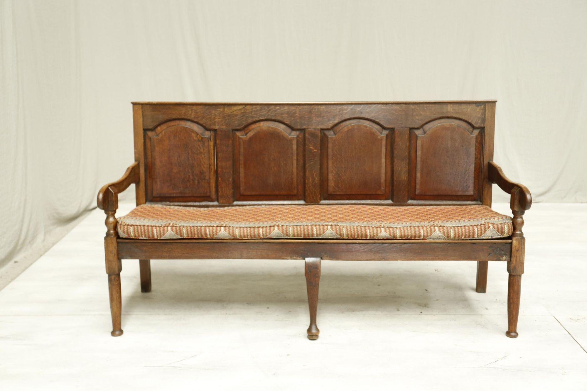 This is a very attractive 18th century oak settle with a beautiful upholstered seat cushion in a kilim type fabric. The overall condition is very good with no weak joints or major faults. It is totally original so it has its quirks which make it all