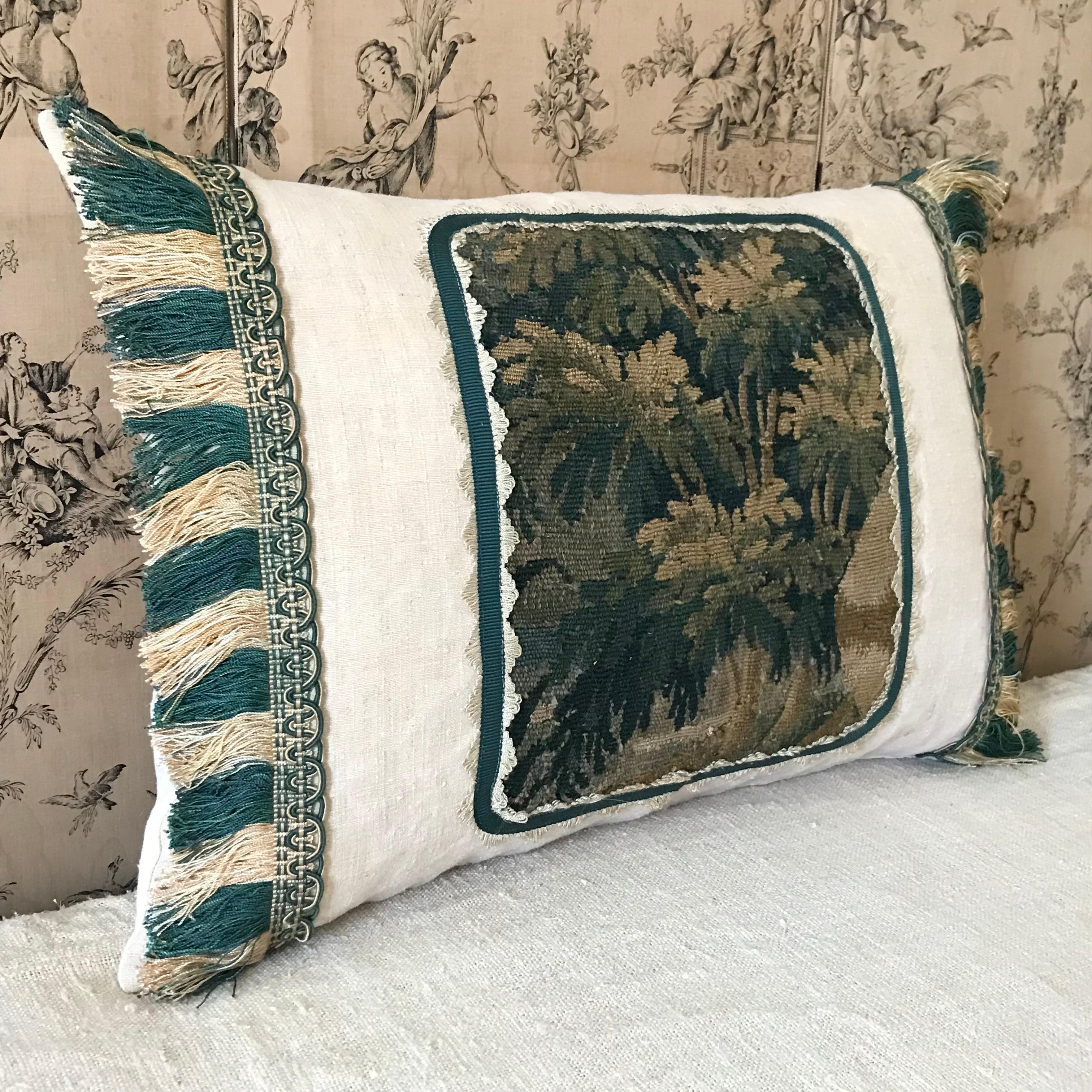 A beautiful 18th century verdure tapestry fragment placed on plain antique French linen and trimmed with Claremont braid and pure silk fringe - plain antique French linen to reverse - hand stitched at bottom - luxurious soft down feather inner pad