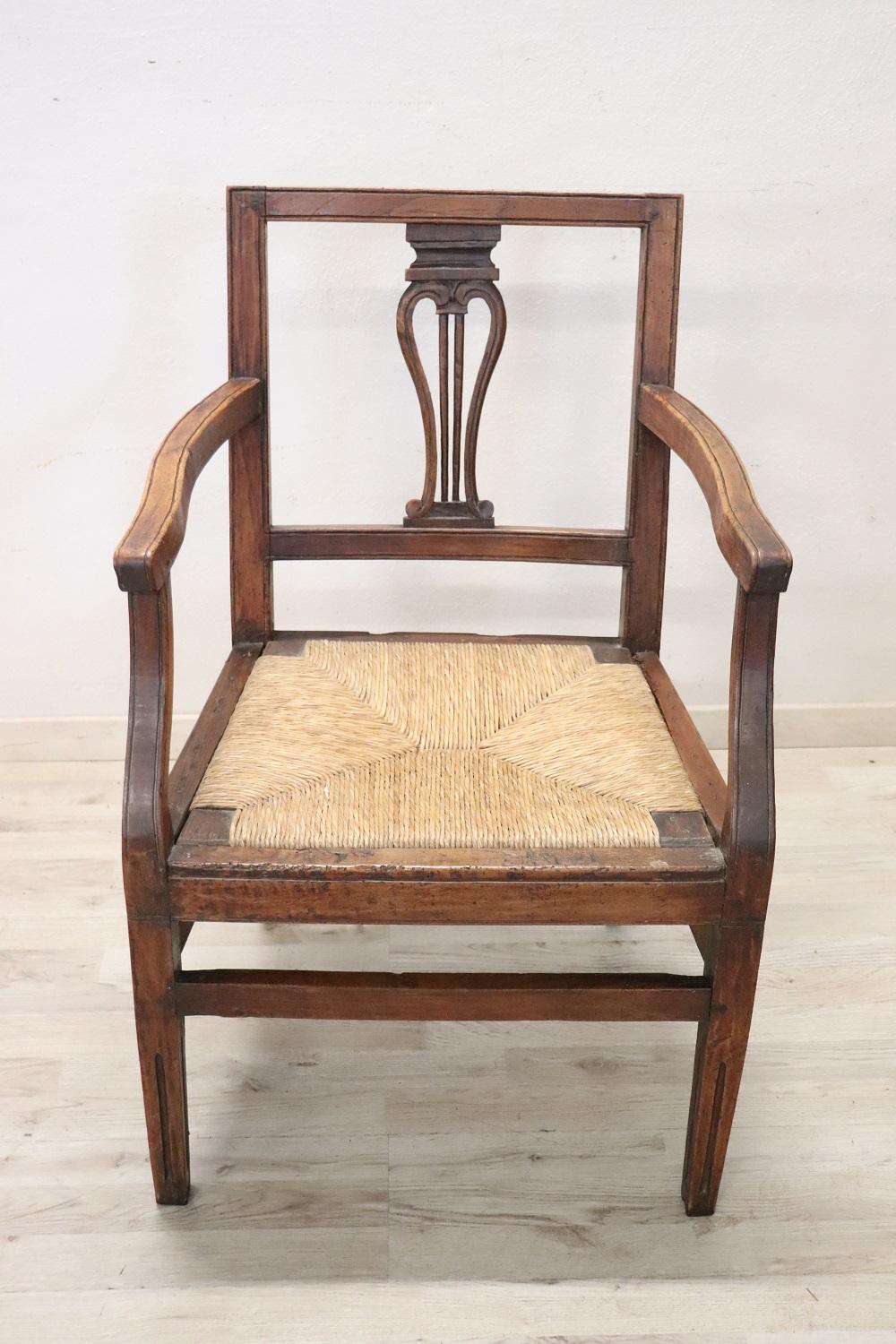 Beautiful 18th century of the period Louis XVI Italian antique rustic armchair in solid walnut wood. The armchair is very simple and essential. Beautifully decoration in wood. The seat is wide and comfortable in rustic straw. The armchair is in
