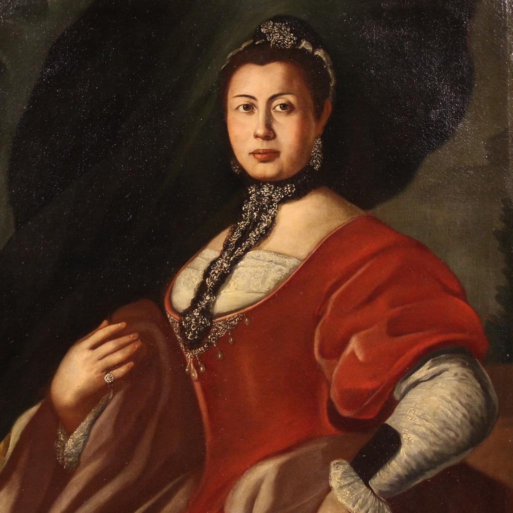 Refined Italian painting from the 18th century. Oil on canvas artwork depicting a splendid female portrait, a noblewoman in an elegant dress embellished with jewels, lace and embroidered ribbons. Painting of excellent pictorial quality, of