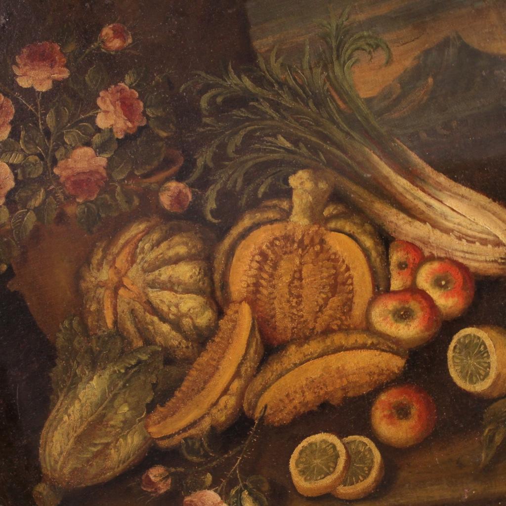 Antique Italian painting from the 18th century. Artwork oil on canvas depicting still life with flowers, vegetables and fruit, for antique dealers and collectors. Oval painting adorned with an antique frame carved, lacquered and gilded of beautiful