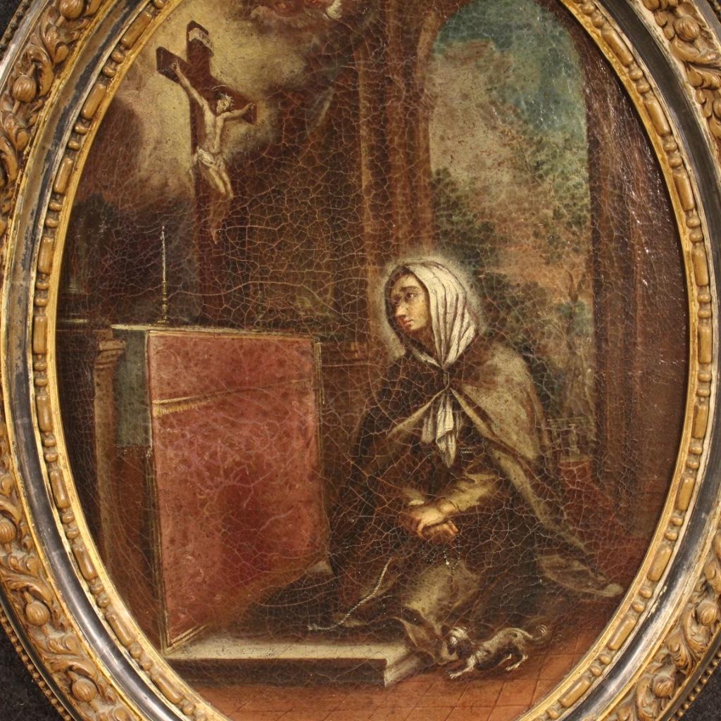 Antique Italian painting from 18th century. Oil painting on canvas depicting a subject of sacred art, representation of Saint Margaret from Cortona of good pictorial quality. Wooden frame carved and lacquered not coeval, of the twentieth century, of