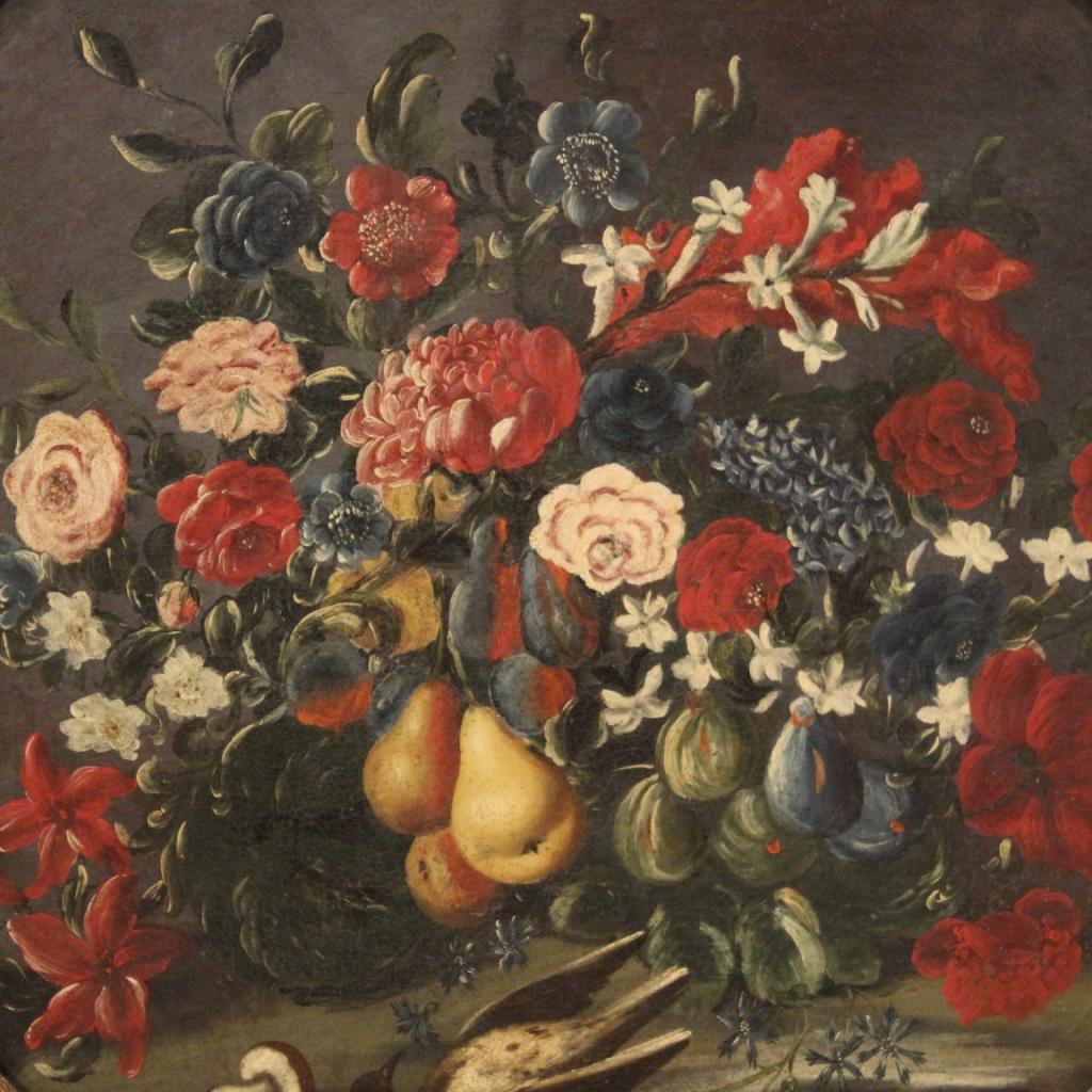 Antique Italian painting from the mid-18th century. Oil on canvas framework depicting still life with flowers and fruit of good pictorial quality. Octagonal-shaped framework with antique carved and gilded wooden frame of beautiful decoration.