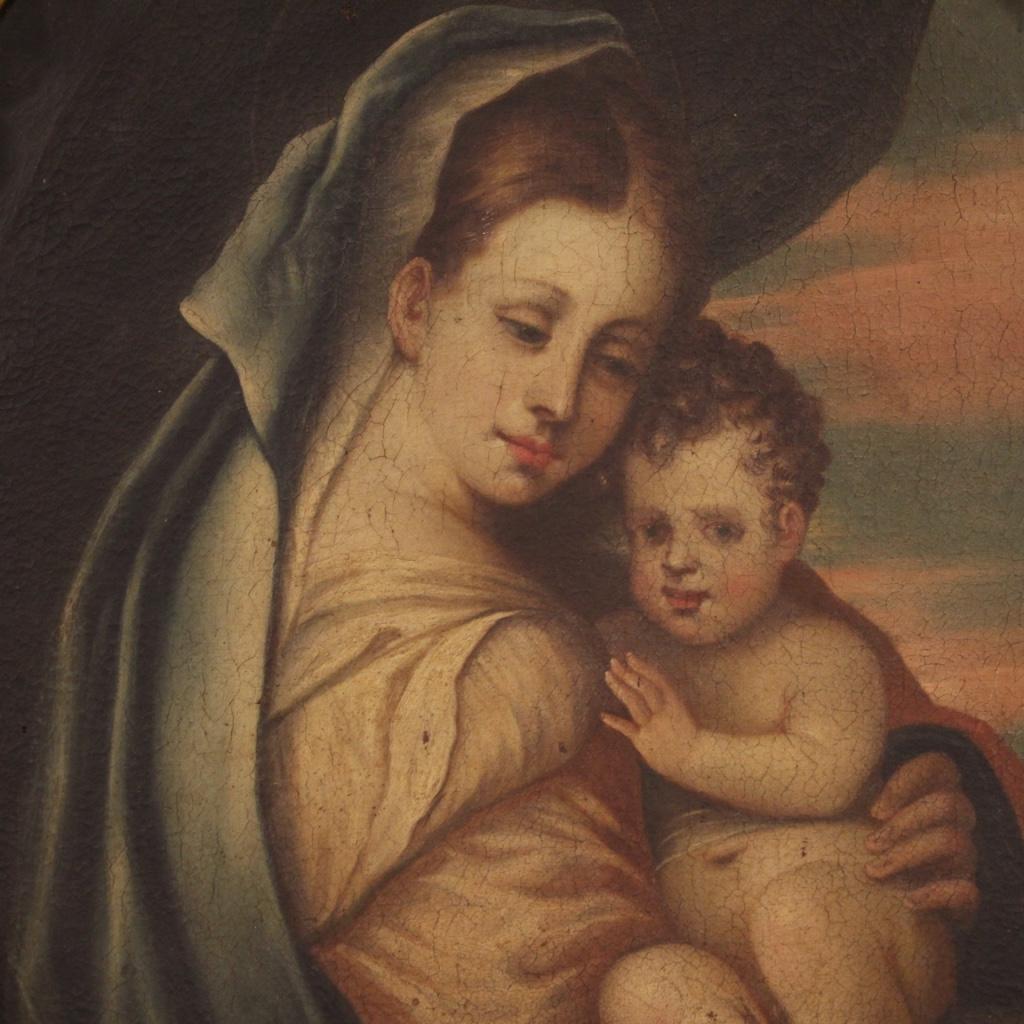 Antique Italian painting from the 18th century. Oval work oil on canvas depicting a religious subject Madonna with child of good pictorial quality. Contemporary carved and gilded wooden frame of excellent quality with a small lack of wooden