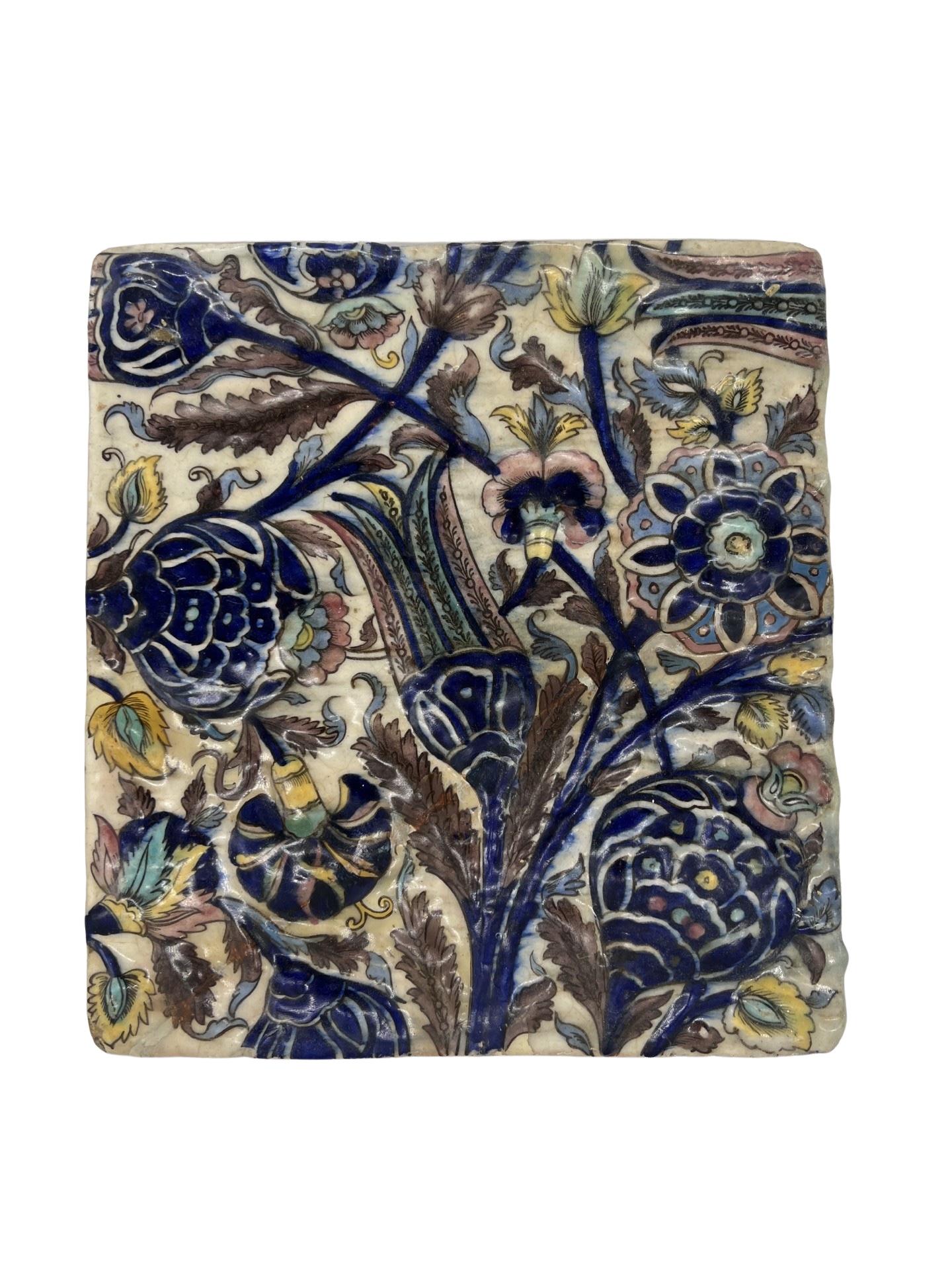 Persian, 18th century or earlier. 
<br>The tile features a tin glaze faience surface decorated with floral and foliate motifs. 
<br>Unmarked.
