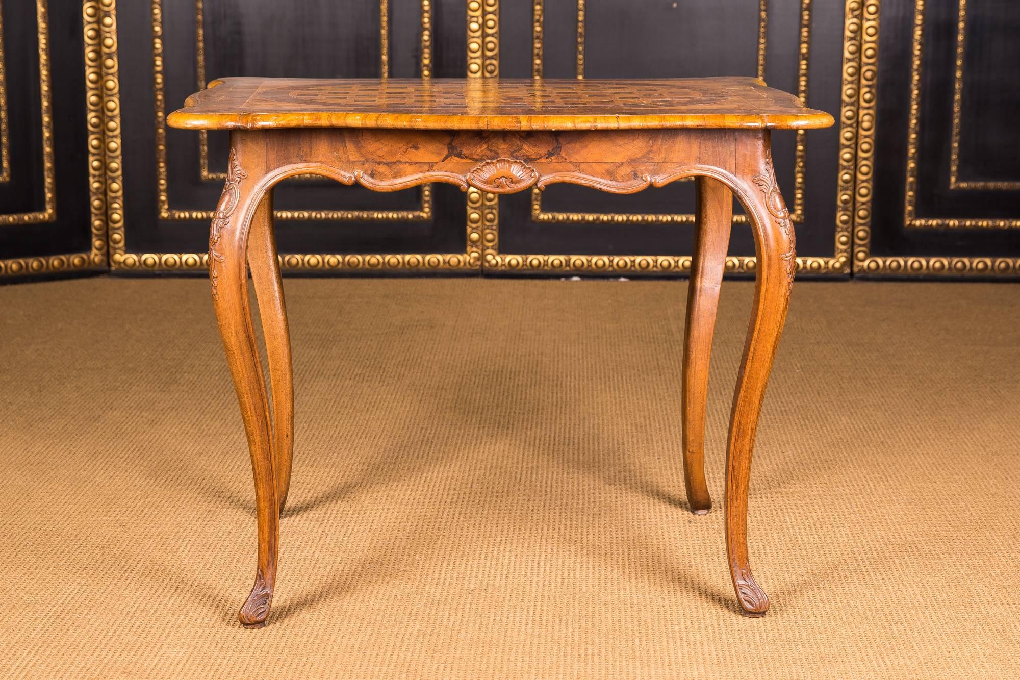 Solid walnut. Overhanging top plate, underneath the body, on a high, elegant curved legs. The whole corpus is veneered with inlaid, different precious woods as inlays.

Please take a look at the detailed pictures.

Excellent warm patina aged over