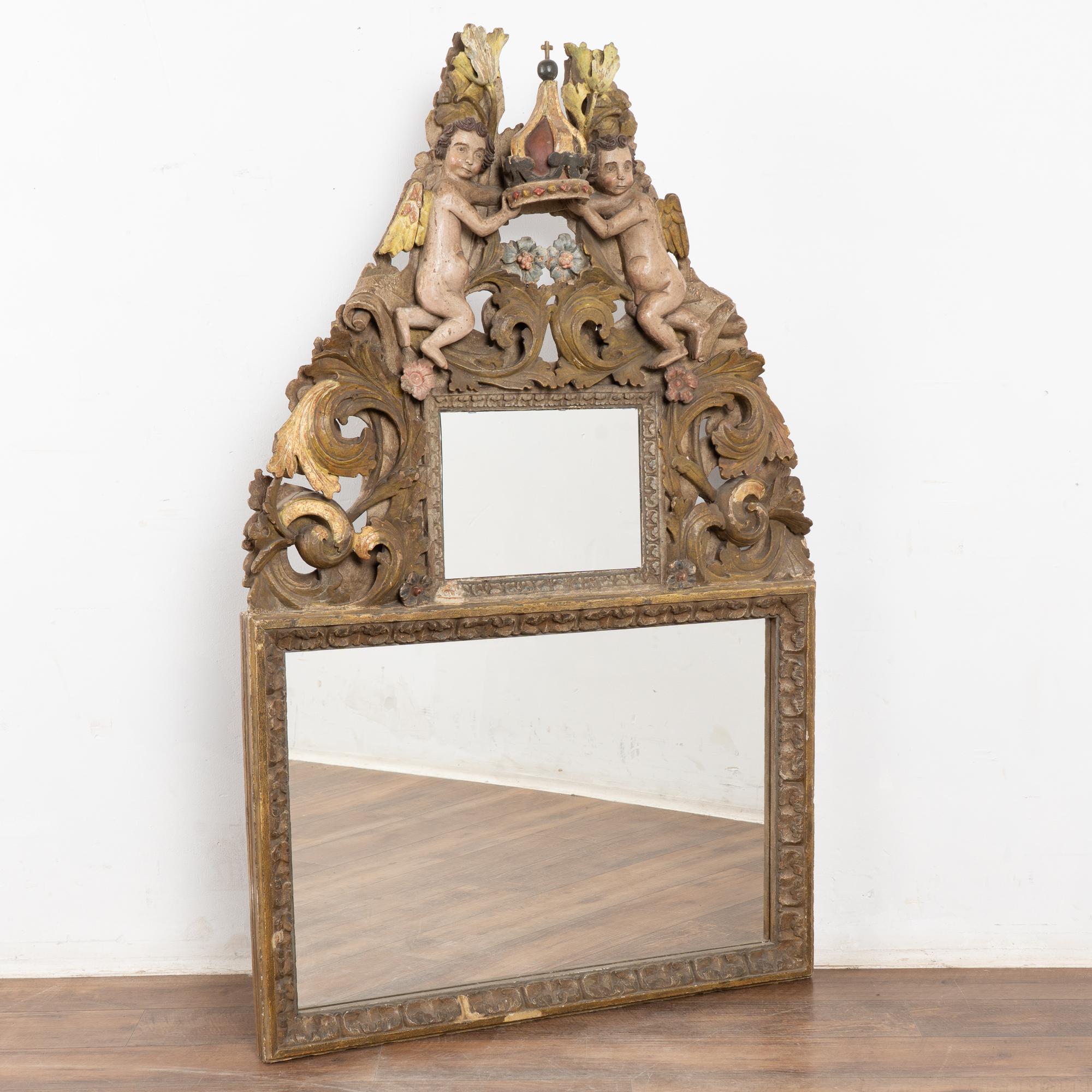Original hand carved and painted rococo altarpiece that has been converted into a stunning mirror. The elaborate carving includes a pair of putti holding a central crown with cross, additional flourishes and flowers.
Please examine close up photos