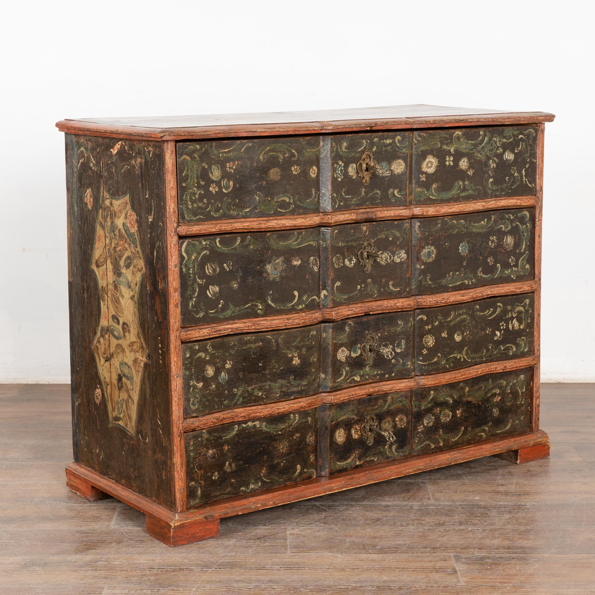This large chest of four drawers is a wonderful find. The hand-painted finish is all original, dating to the mid to late 1700's. 
The lovely floral painted details and flourishes were a traditional folk art design of the era set against the faux