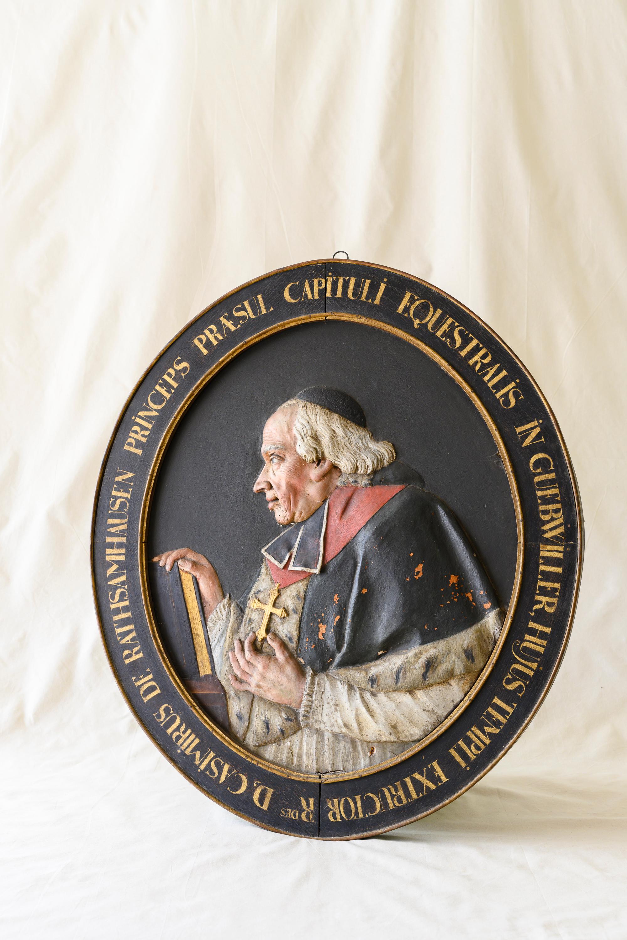 Oval carved wood portrait of Casimir-Frédéric de Rathsamhausen-Wibolsheim (1698-1786). Known as Dom Léger, he was a Catholic cardinal at the Abbey of Murbarch in France's Rhine valley. Carved from a single massive piece of wood, likely oak, with