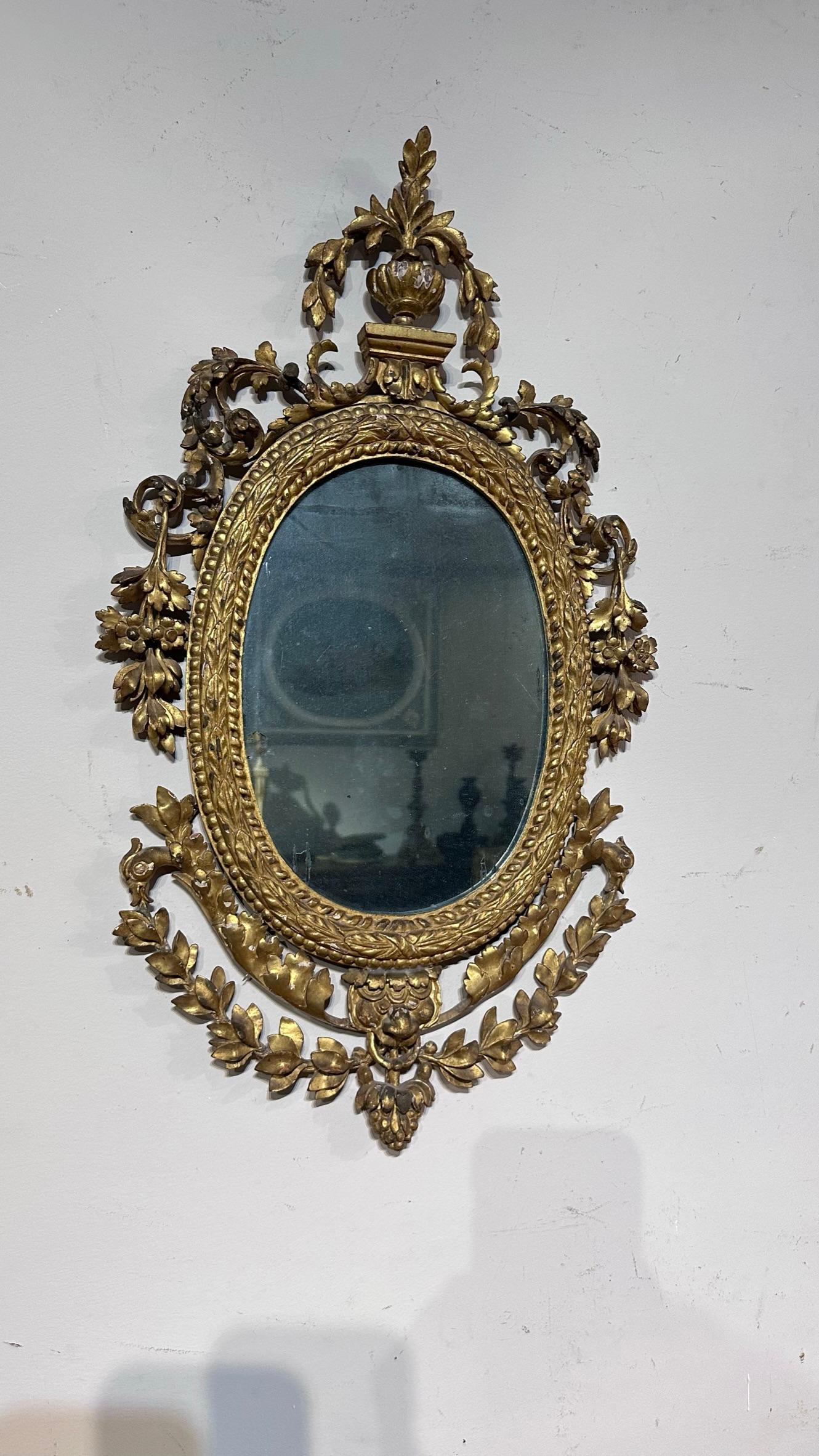 Ovaler Spiegel aus fein geschnitztem Kiefernholz und vergoldet mit Blattgold und originalem Quecksilberlicht. Typische italienische Manufaktur im Louis-XVI-Stil der späten 1700er Jahre.

Maße HxBxT 64 x 35 x 3,5cm