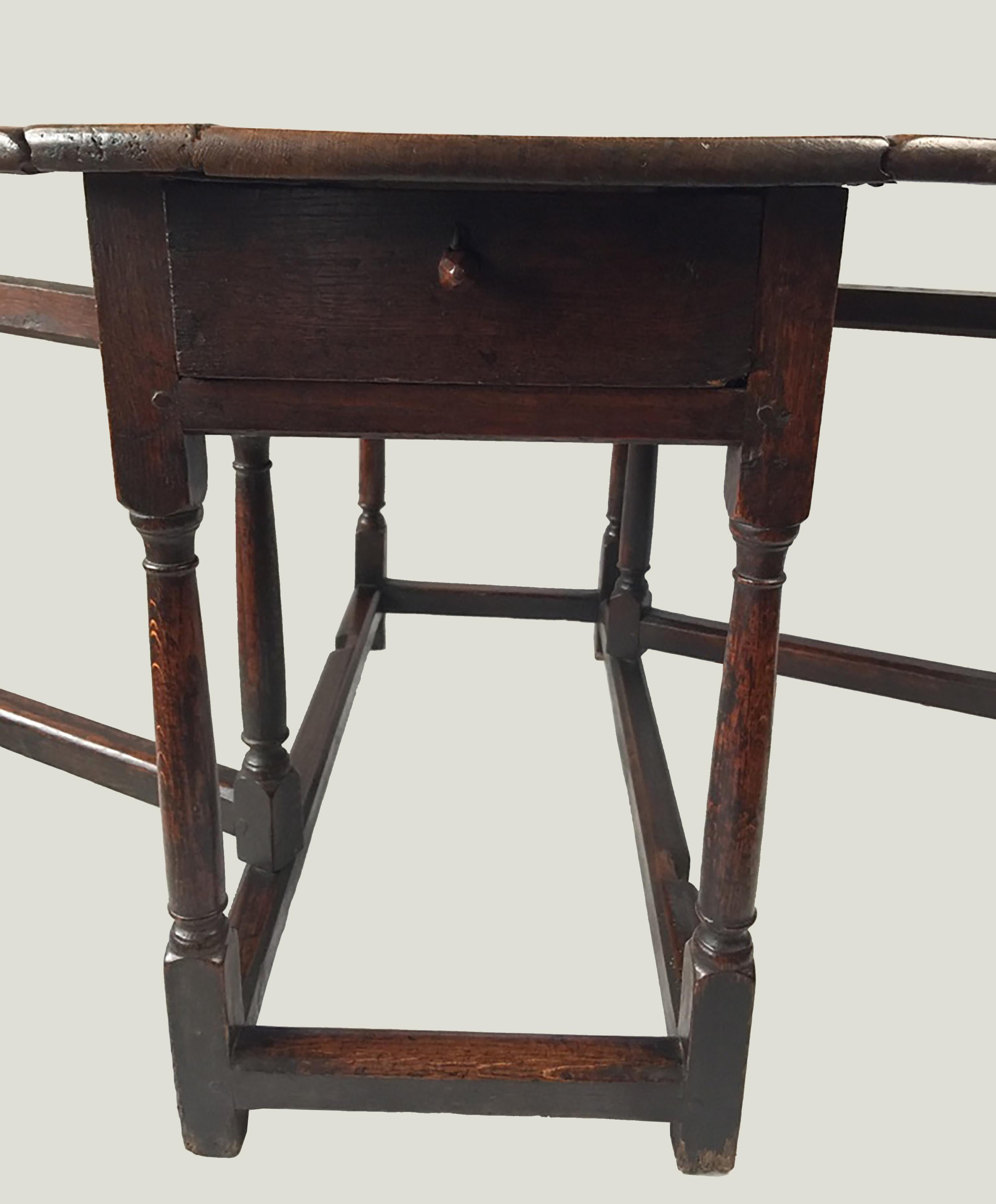 Very early 18th-late 17th century oak gate leg table, in good condition for its age. Well cared with a good patina. Really lovely carved drawer knob.