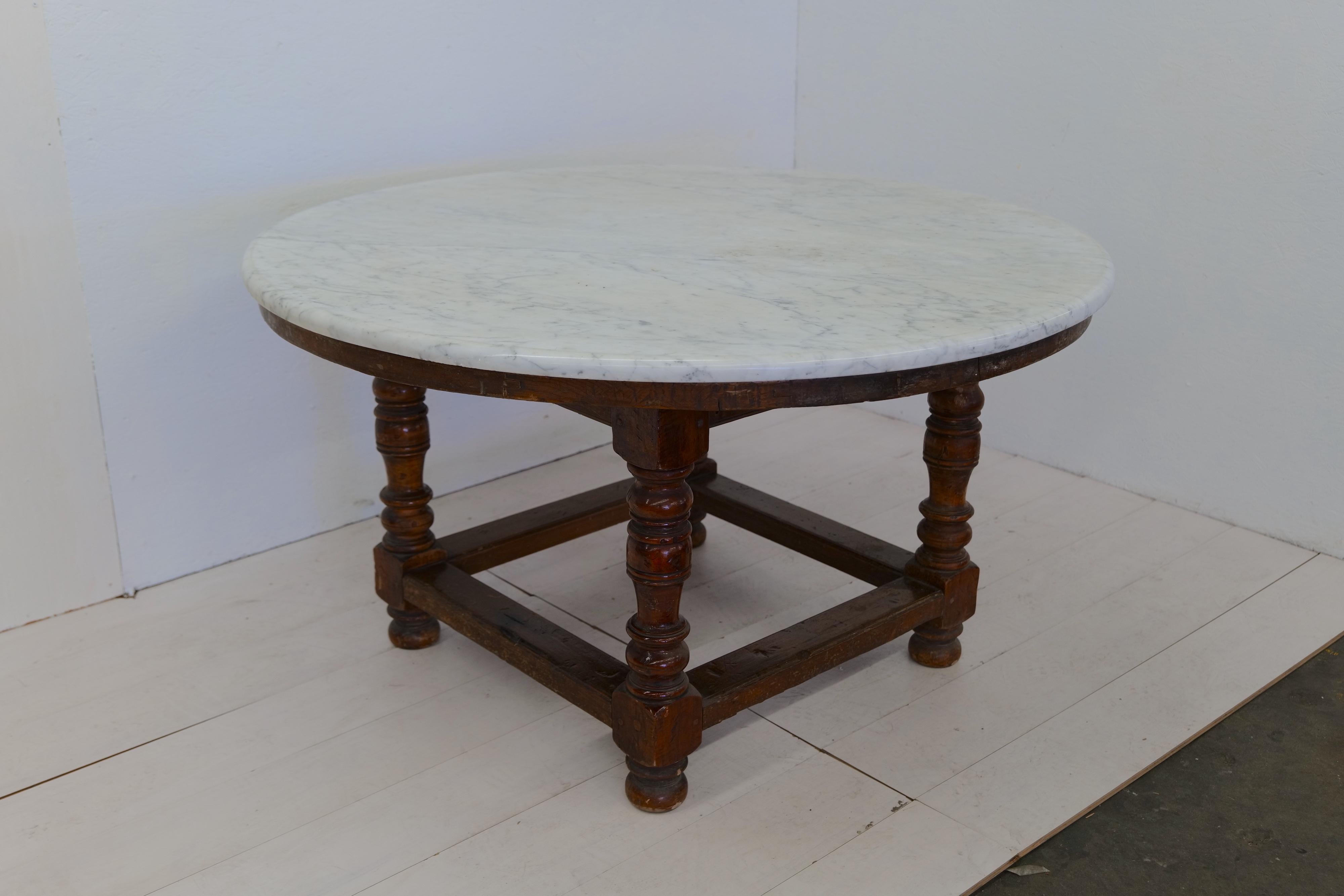 The 18th century Oversize Wood and Marble Dining Table is a grand and luxurious piece of furniture. The table features a sturdy wood base that provides stability and support. The highlight of this dining table is its impressive 1-inch thick carrara