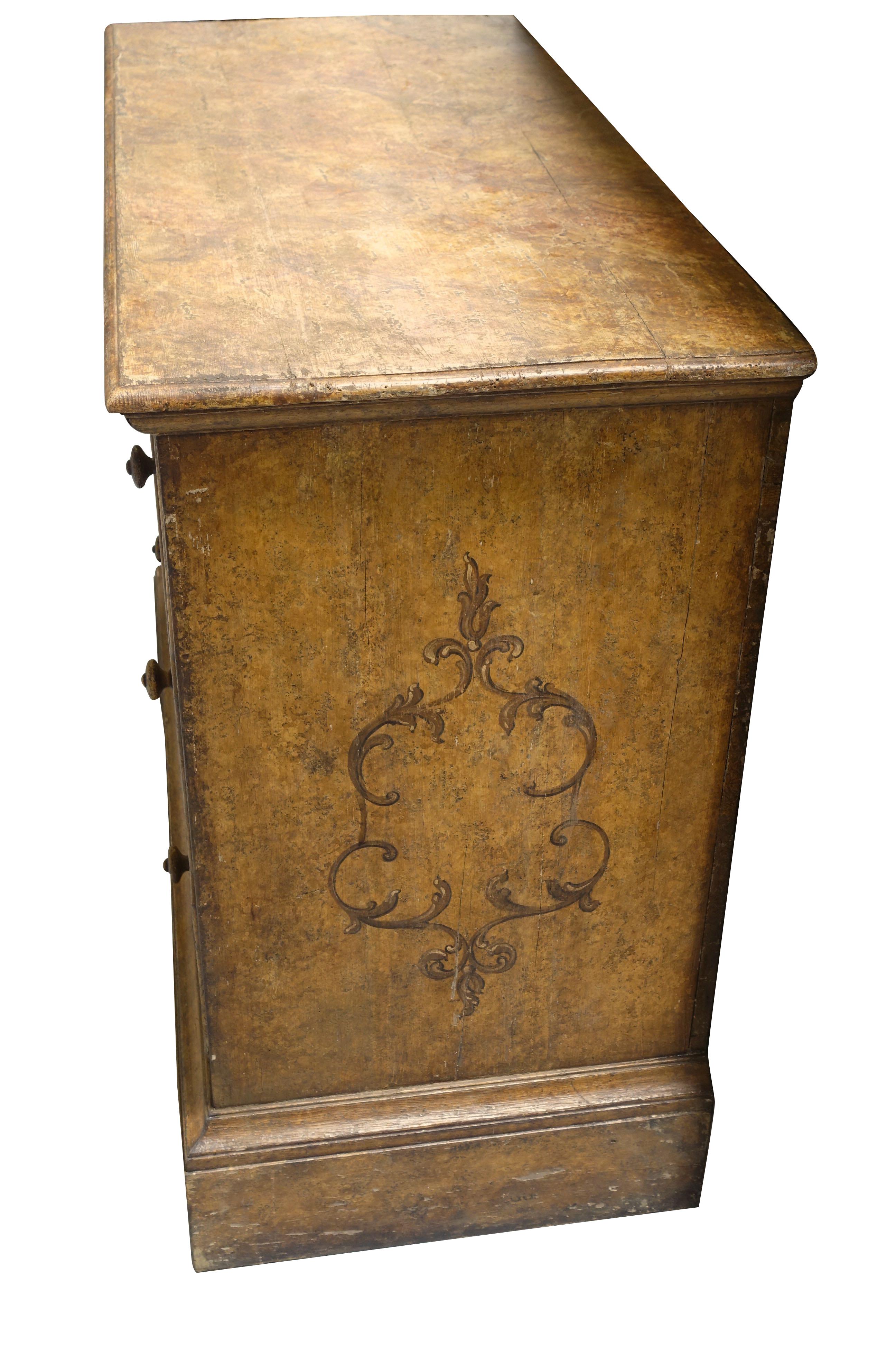 18th century Italian original faux painted three-drawer commode.
Decorative design details painted on sides and front drawers.
 