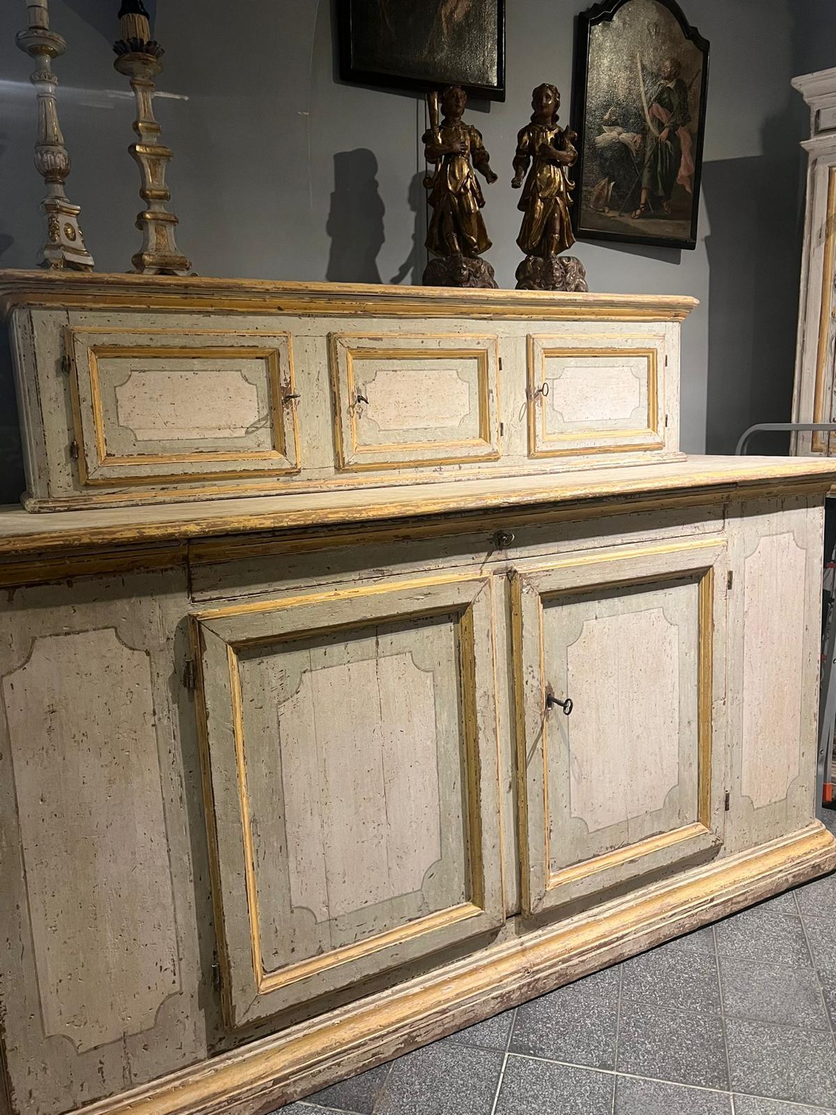 Beautiful sacristy furniture in painted poplar wood. This piece of furniture features an original lacquer. Particularity in the sides where there are doors and the sliding tray used as a shelf in the central body, Tuscany, early 18th