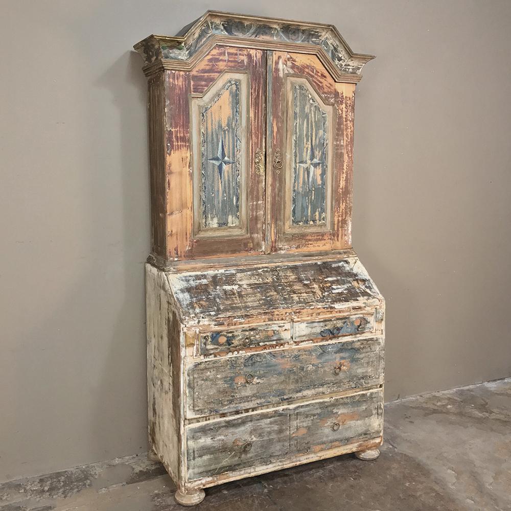 18th century painted Swedish secretary, bookcase features a charming distressed painted finish with solid brass hardware that will add a splendid Old World rustic charm to any room! Flat-topped arched crown lends a distinctive look, with tailored