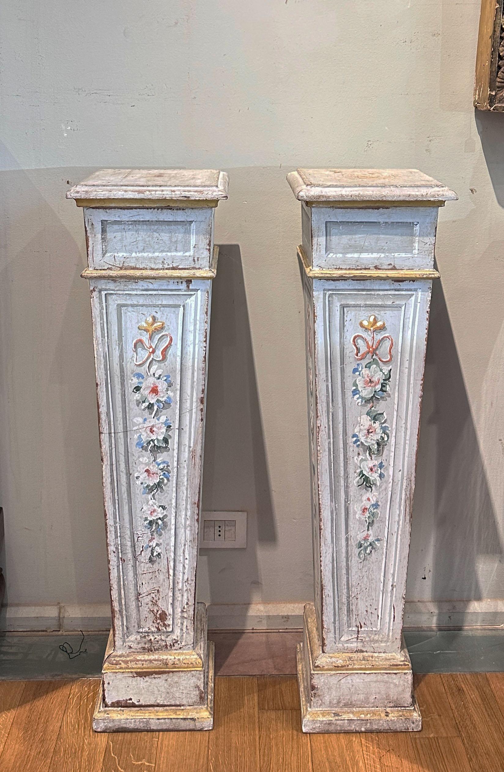 Pair of elegant columns made of carved and painted wood. Their shape is rectangular, with a slight taper toward the bottom, giving them a graceful and harmonious appearance. The decoration of the columns is symmetrical and reflects the aesthetic
