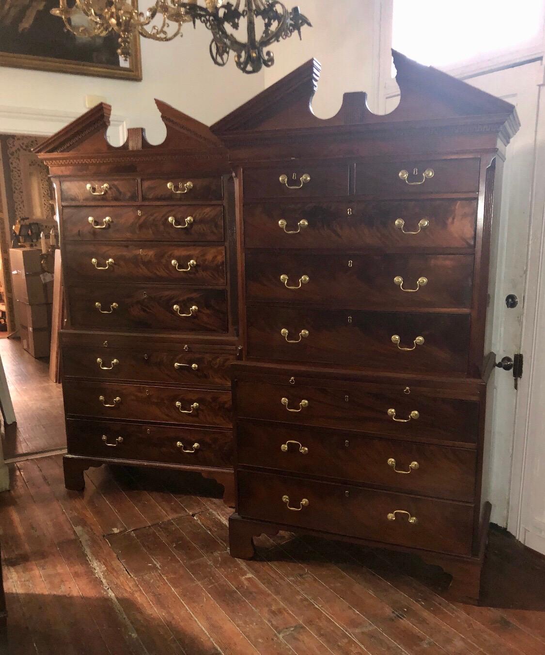 This rare pair of George III period mahogany Chippendale chest on chest with broken arch pediments have dressing / brushing slides. These finely crafted chest on chest come in three parts having graduated drawers with swan neck pulls and terminating