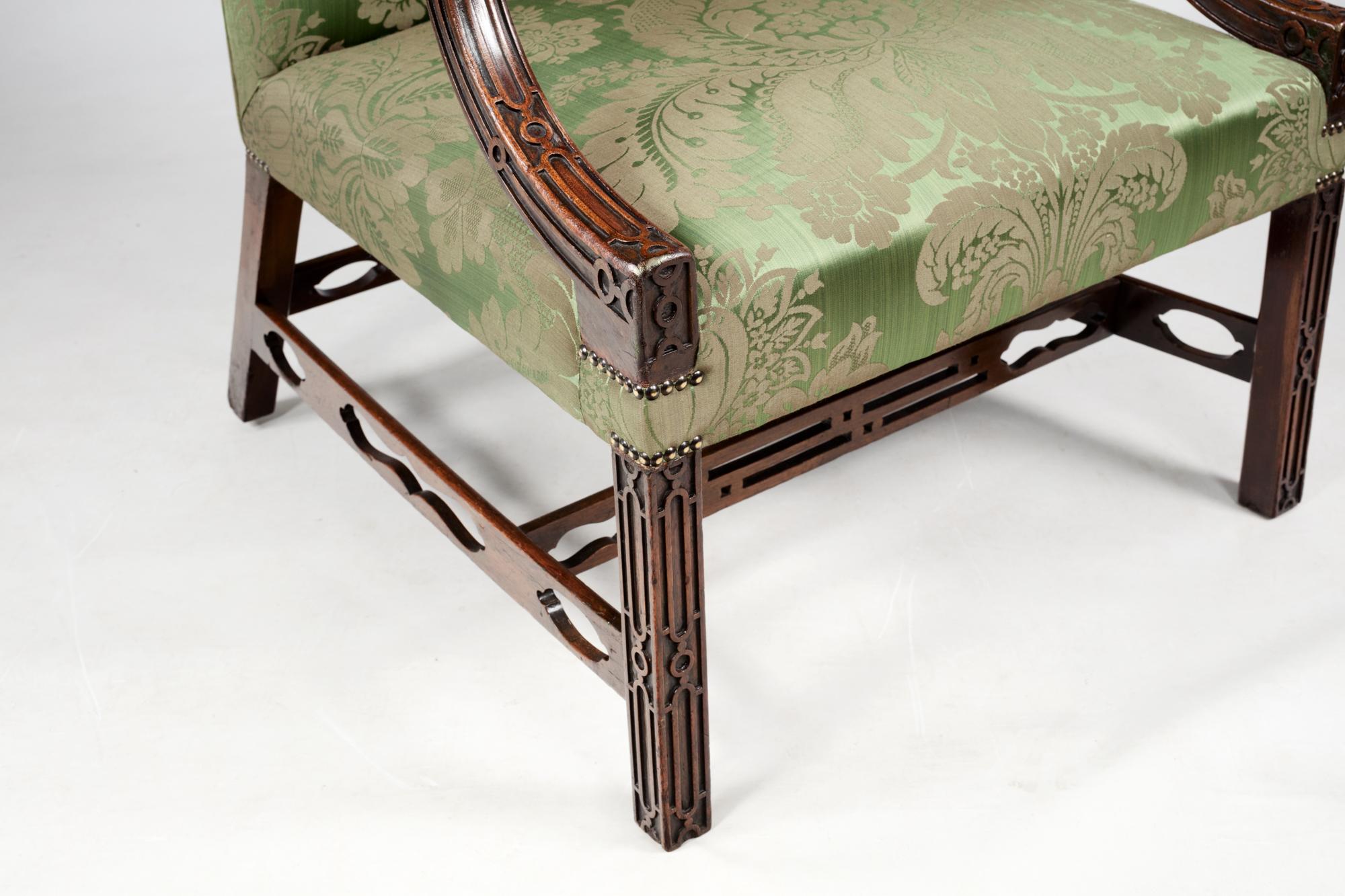 Pair of 18th century Chinese Chippendale-style armchairs with newly upholstered seats and backs in green damask fabric. This pair of chairs features blind fretwork on the arms and legs. Circa 1790.