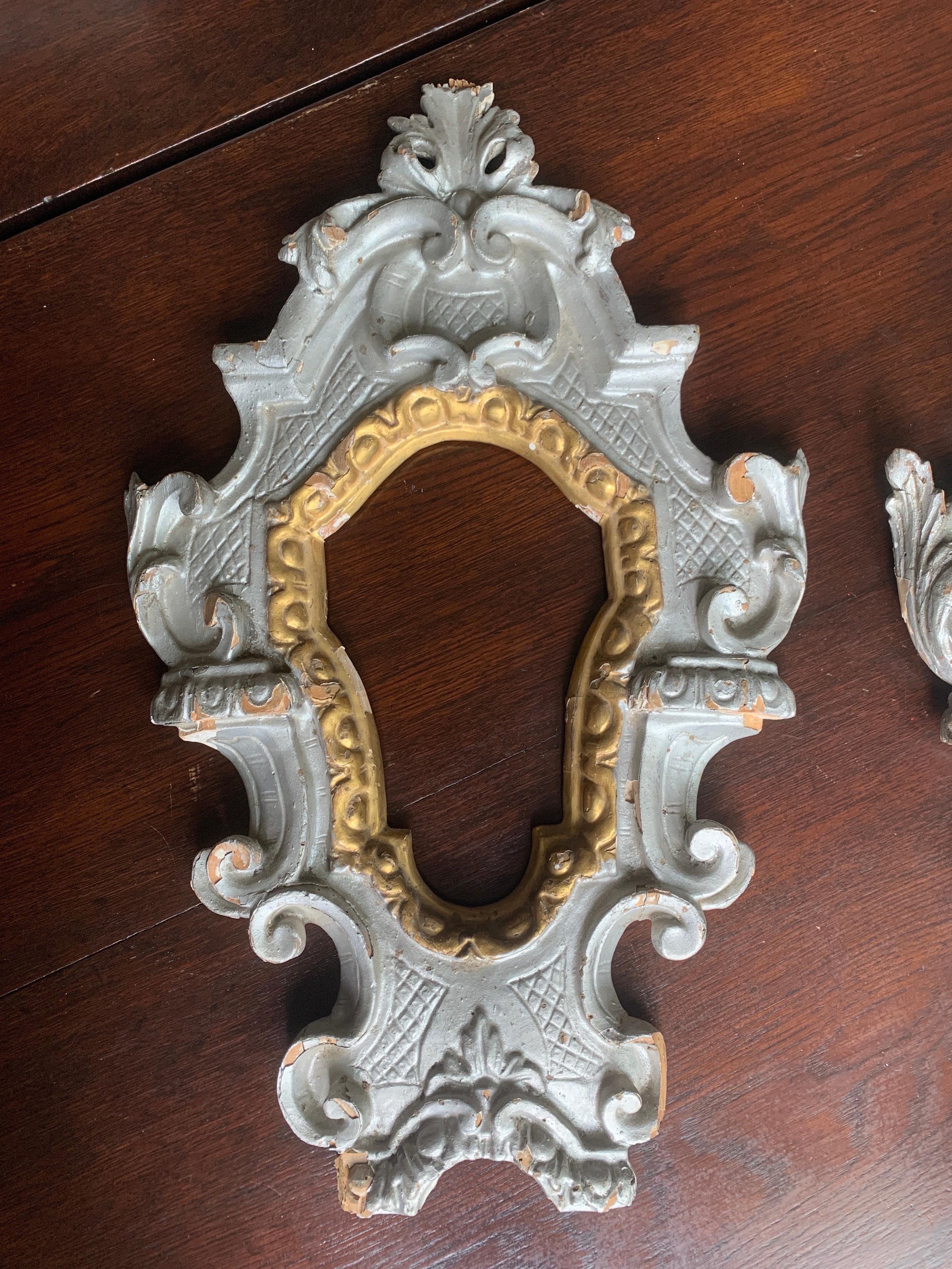 Exquisite Italian wall mirrors made in hand carved wood hand painted in light grey with gilded inner parts and floral motifs one of them still wearing the original glass. There were no restorations so far but such could be done in order all parts to