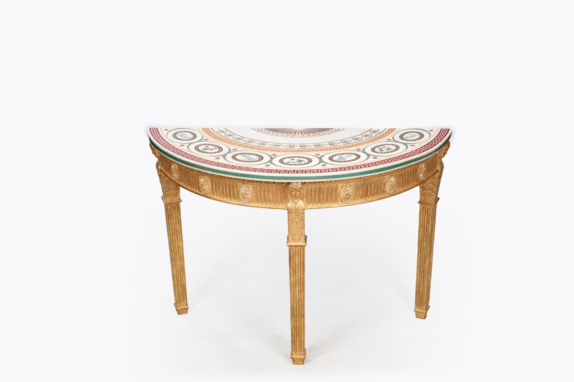 Paire de très belles tables d'appoint en demi-lune dorée Bossi du XVIIIe siècle, avec frises sculptées dorées et plateaux de marbre incrustés de compositions colorées Bossi dans le style de Robert Adams C.C. 1790. Elle présente des motifs vibrants,