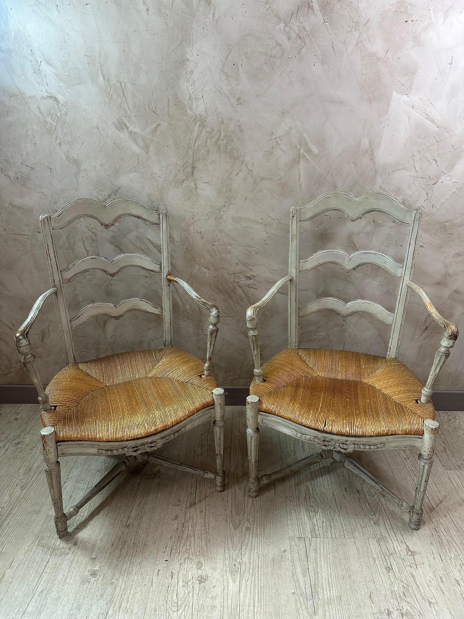 Lovely pair of 18th-century of French provincial armchairs with straw seats and a beautiful gray patina due to use and age. Good overall condition. Comfortable. Ideal for a country home.