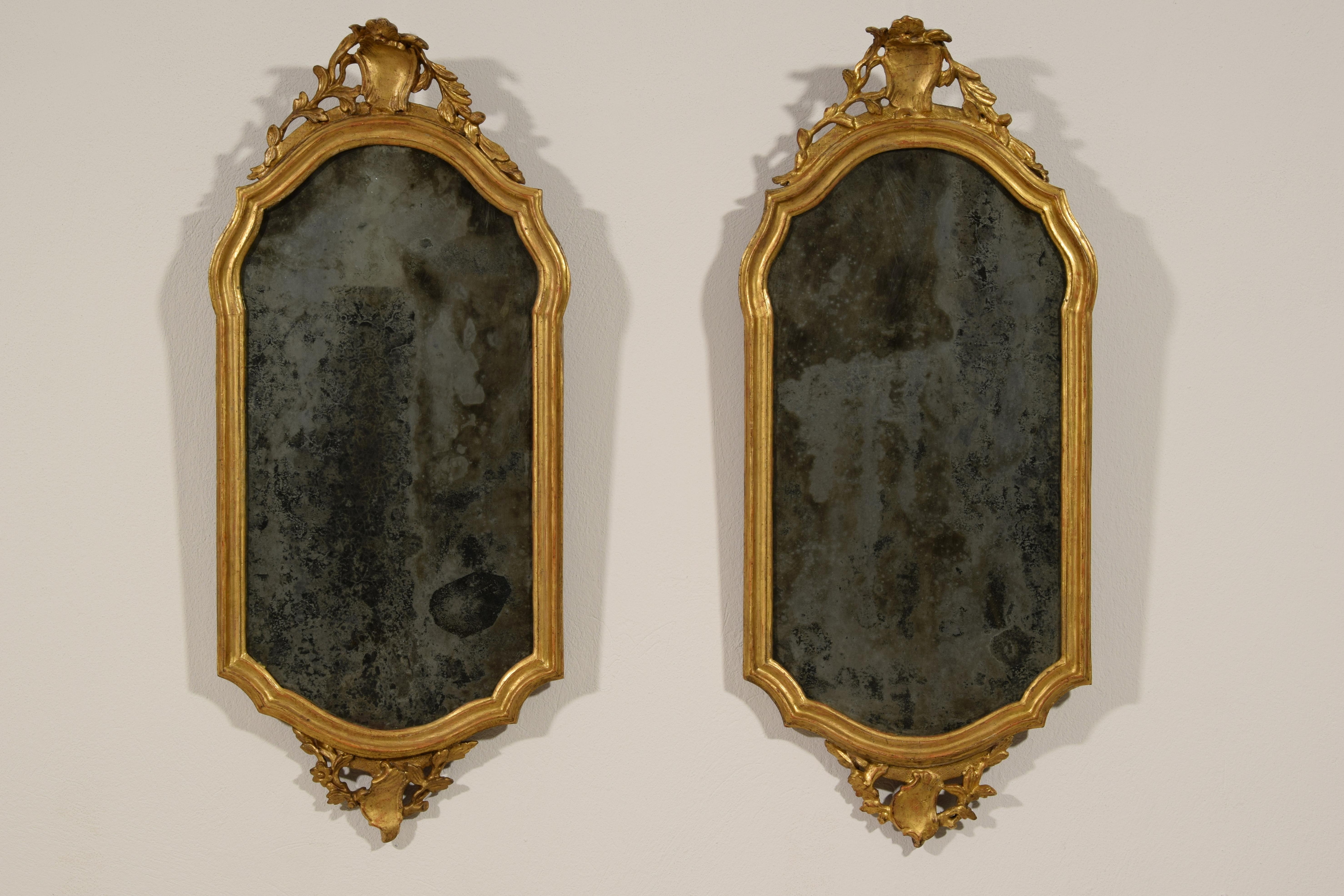 18th century, pair of Italian carved and giltwood mirrors
The pair of mirrors was made in Venice, Italy, around the middle of the eighteenth century, Louis XV era.
The carved and golden wooden frame, oblong, has a mixed pattern with mouldings