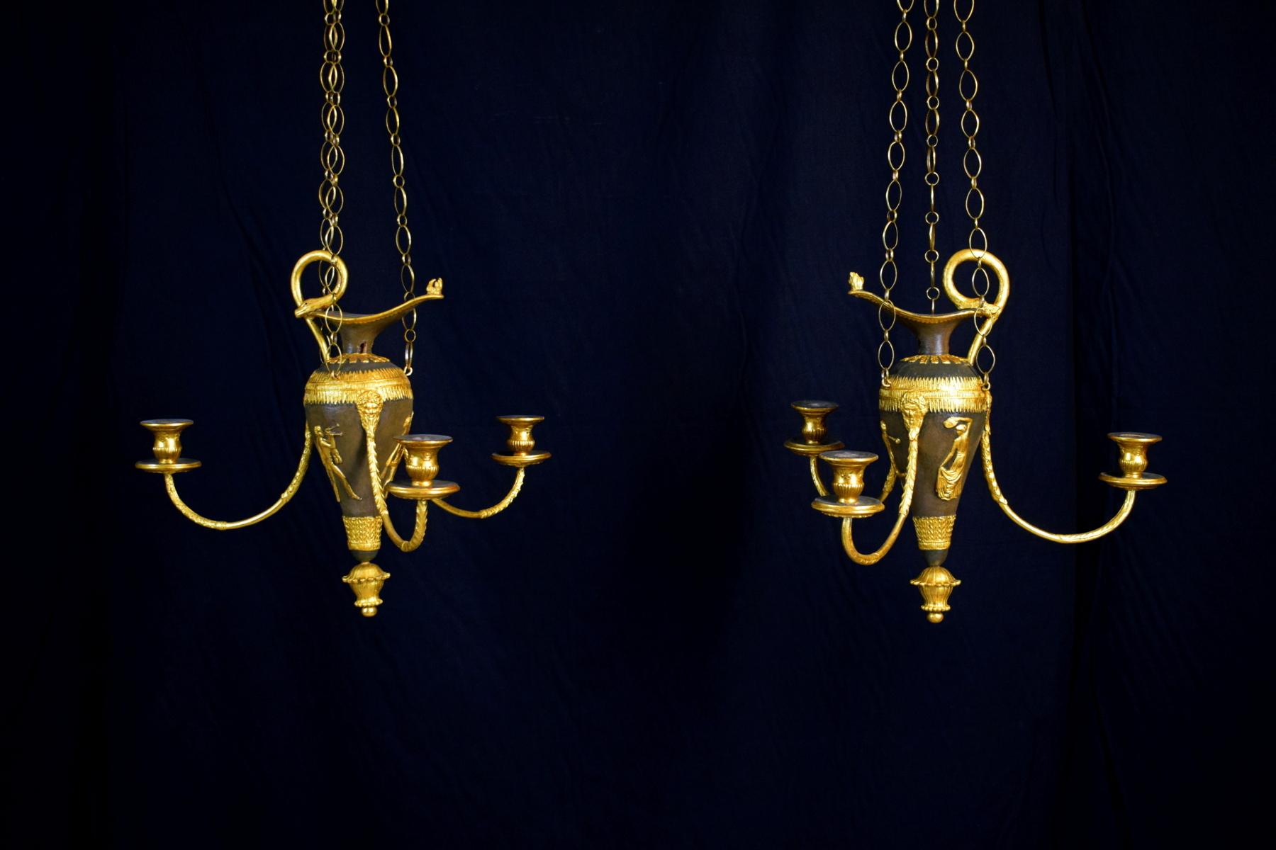 Last quarter of 18th century, pair of Italian lacquered wood and gilded Pastiglia chandeliers

The chandeliers are made of carved and lacquered wood in bronze imitation with gilded pastiglia decorations. They are composed of a body shaped like an