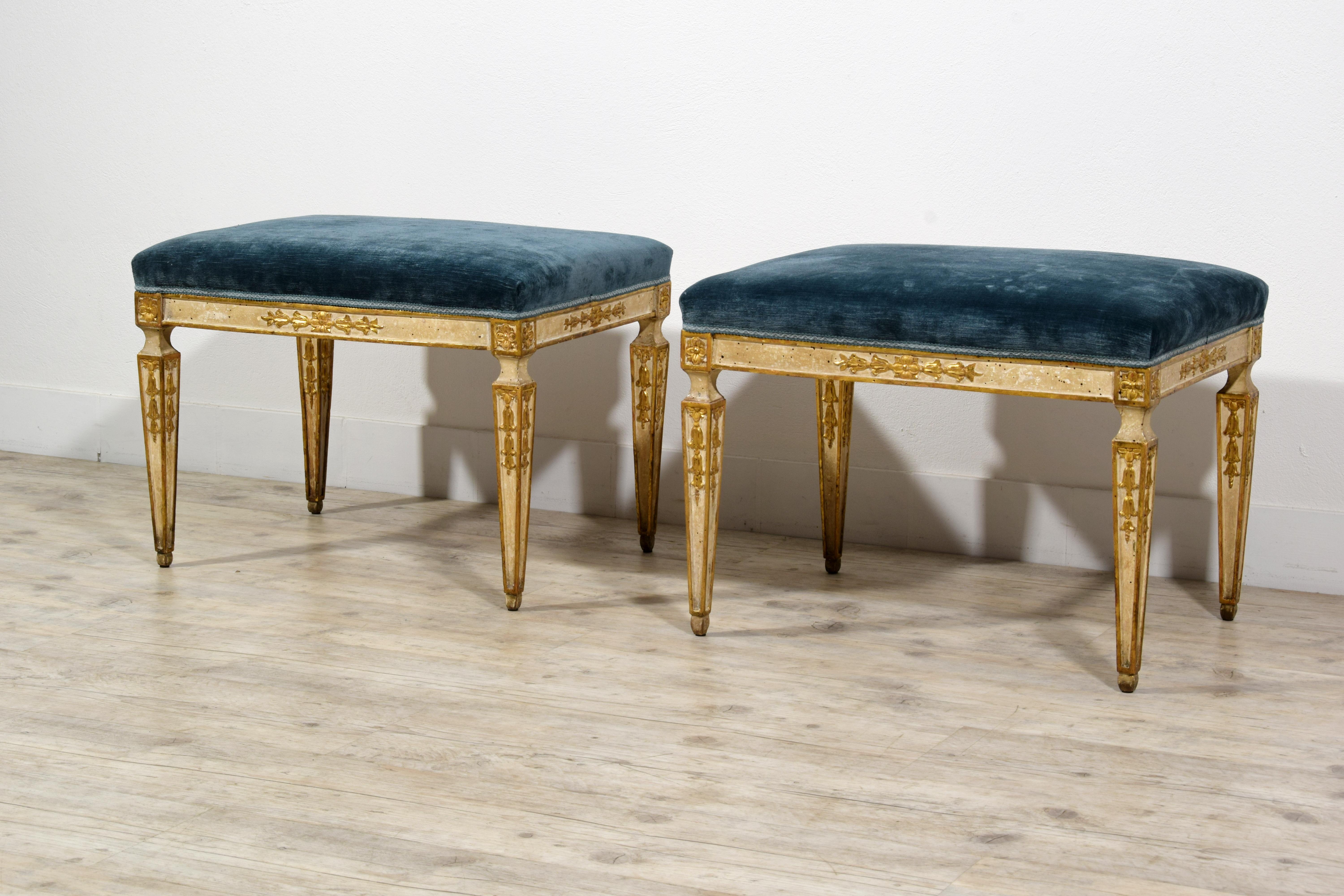 This pair of center stools was made in Naples towards the end of the 18th century, during the Neoclassical period.
The rectangular seats are upholstered in blue velvet fabric, which is in good condition. The structure is made of carved wood,