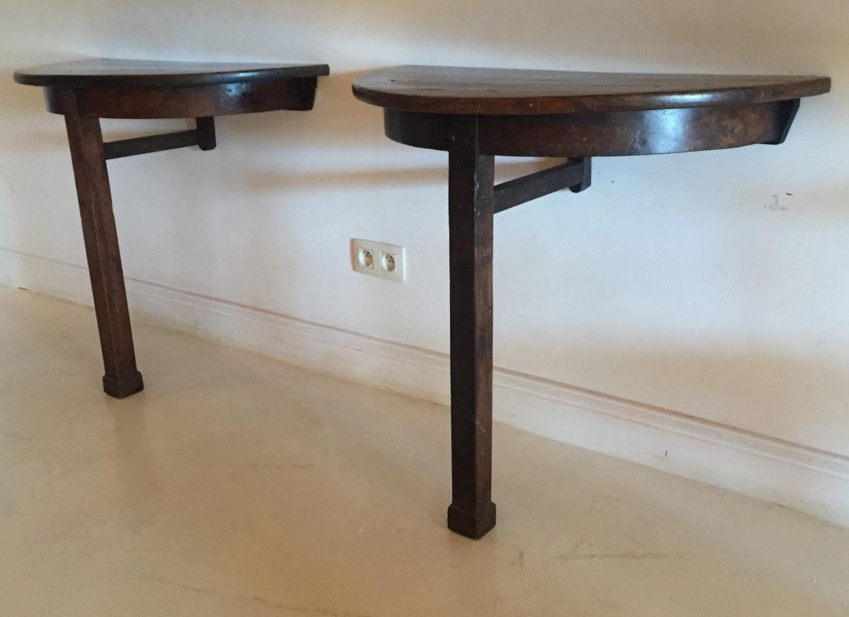 A pair of Italian walnut neoclassical consoles. These wall fixed consoles have a simple but elegant design executed with beautifully aged walnut. The tops of the tables are each made from two wide boards with matching grain. The feet and support