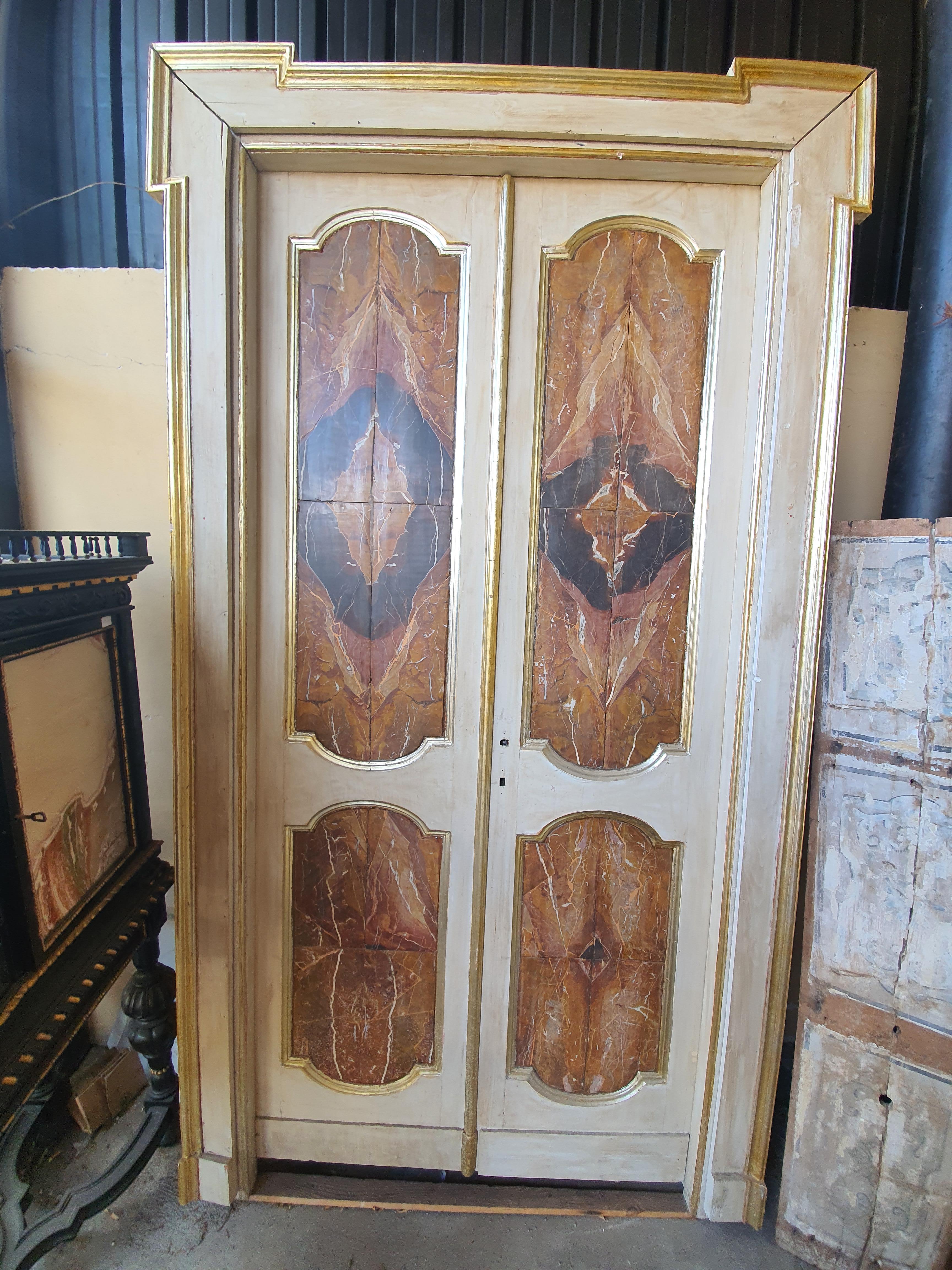 Rare and ancient pair of large doors in lacquered and gilded wood. Particular workmanship in the panels, veneered in Sicilian jasper marble, with open stain.