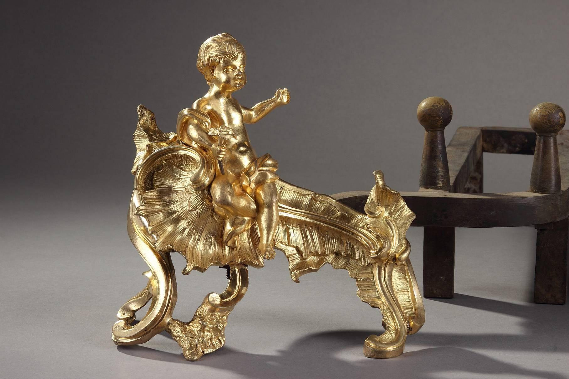 Pair of gilt and chiseled bronze andirons. They are decorated with Cupids holding a cup and a flower, sitting on a Rocaille base sculpted with gadrooned foliage and scrollwork. Louis XV period.,

circa 1760
Dimensions: W 12.6 in, D 21.3 in,  H