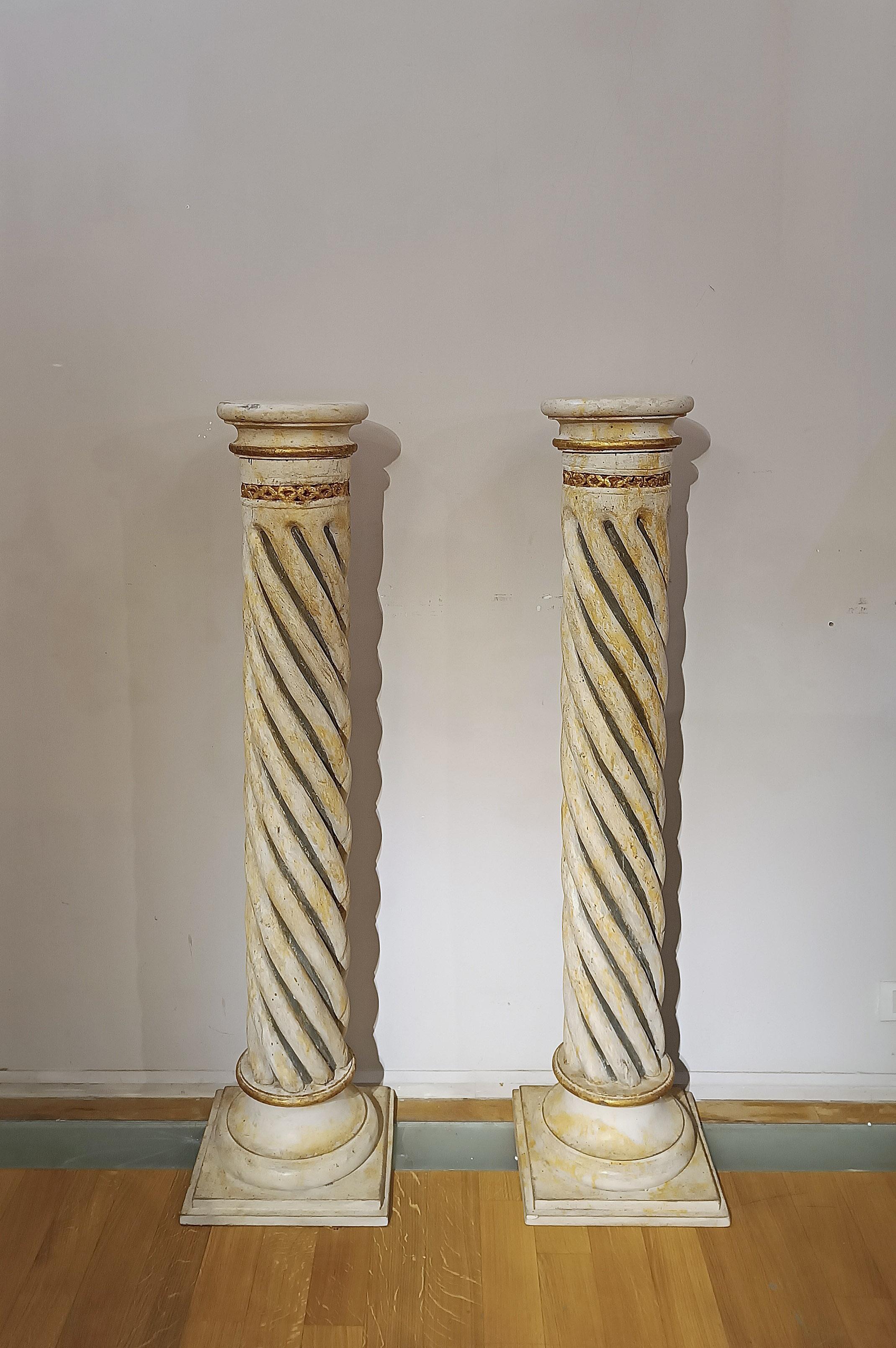 Pair of wooden twisted columns, finely carved and painted with a black and yellow duotone. The columns are enriched with pure gold leaf gilding, with particular attention to details such as the final bull and the upper part decorated with geometric