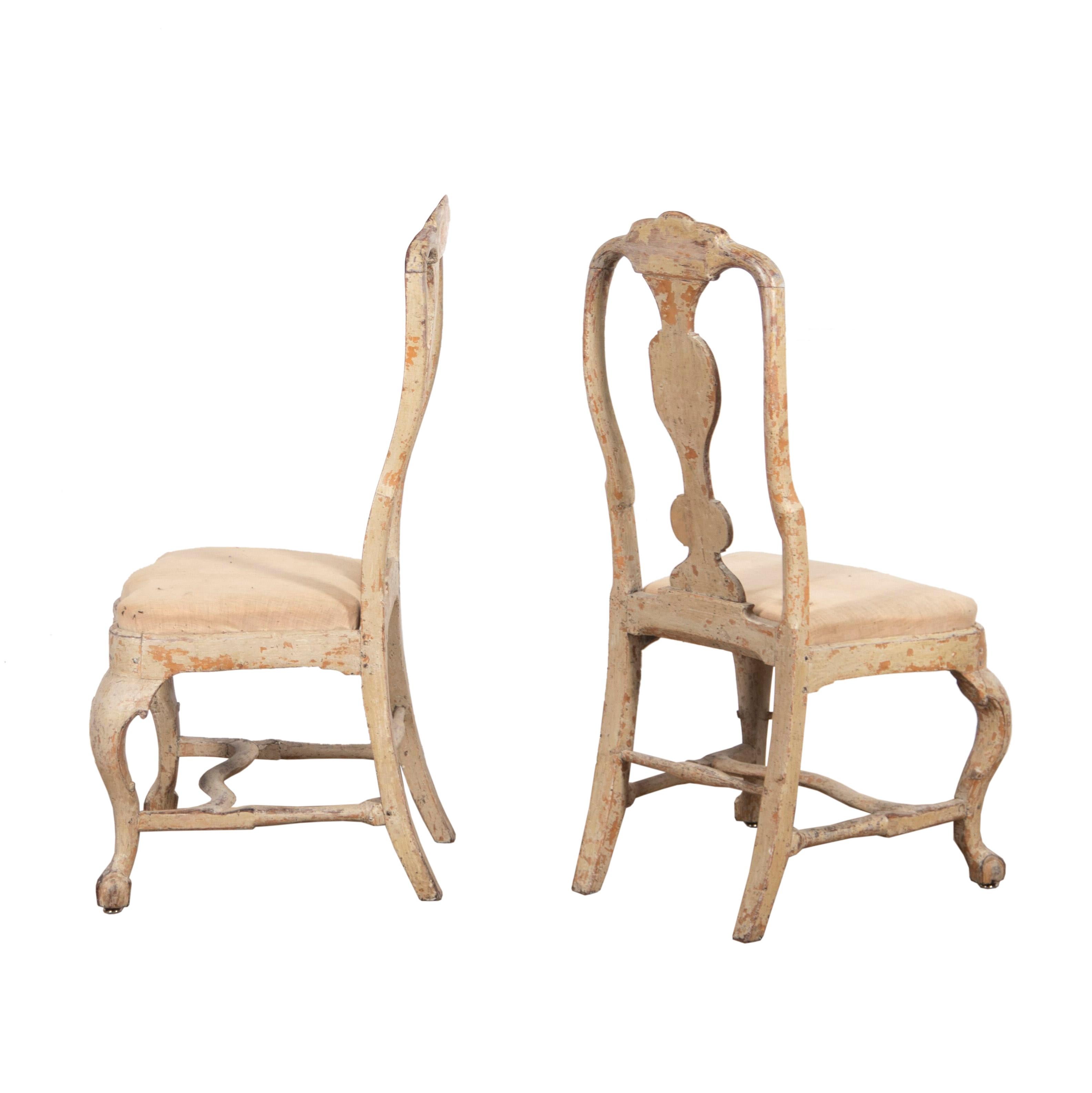 A period pair of side chairs from Lindome in Sweden with decorative carving to the back and front stretcher. Cabriolet legs taper to claw and ball feet. This piece has been dry scraped to original paint.