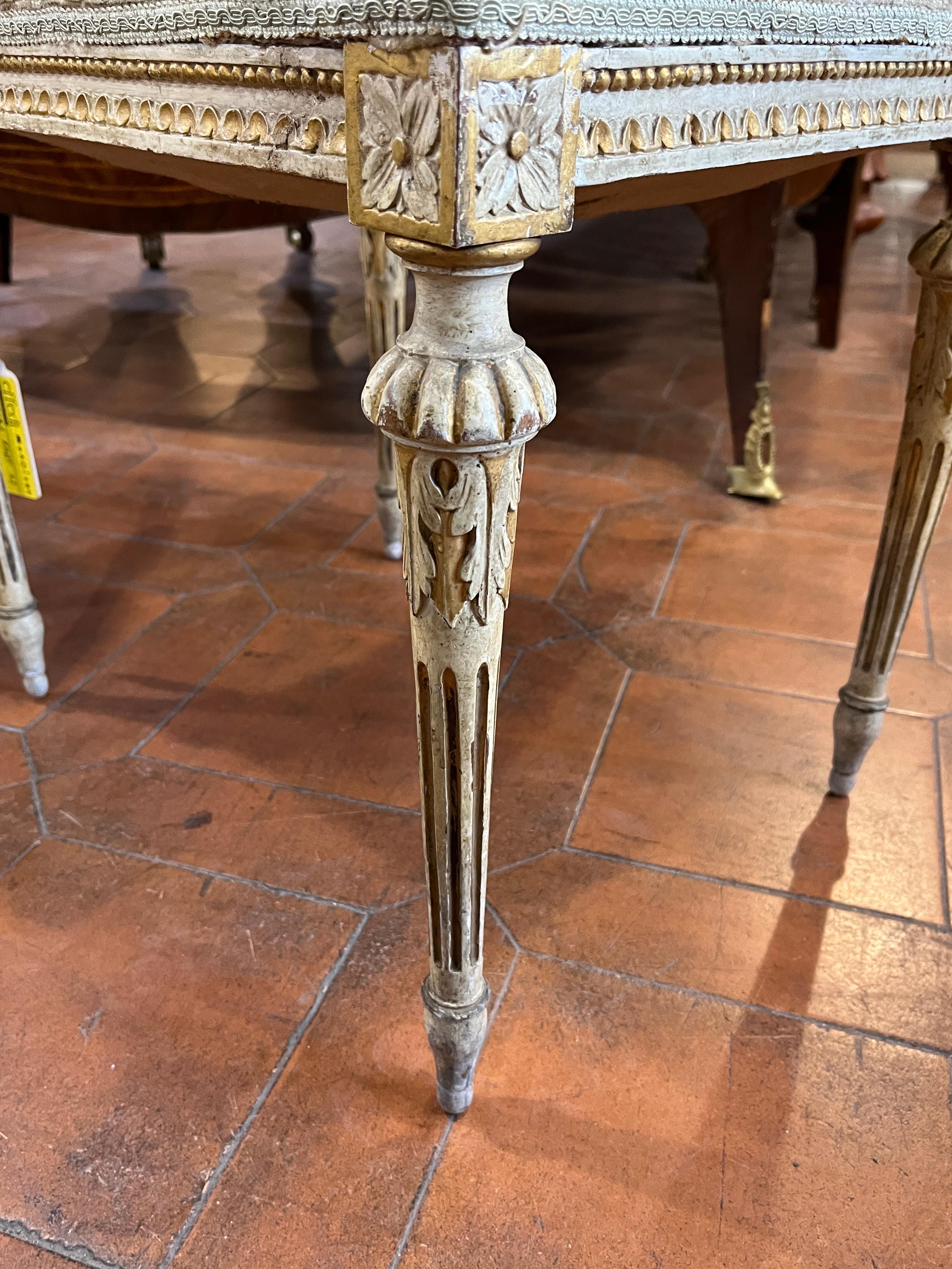 Fantastic pair of Venetian stools, Louis XVI era, circa 1780-90. Lacquered and gilded, classic fluted leg with acanthus leaves and border embellished with squares with flowers and a slight greek running around the entire perimeter.Very good state of