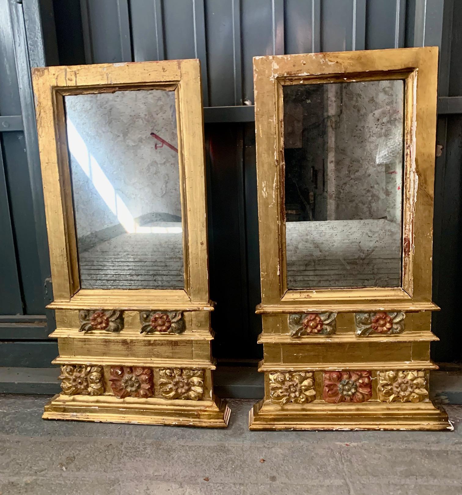 Paire de miroirs baroques espagnols, du XVIIIe siècle, en bois doré et polychrome, dans la partie inférieure en bois sculpté à la main avec des motifs végétaux, en or, vert et rouge. L'un des miroirs présente quelques marques correspondant à leur