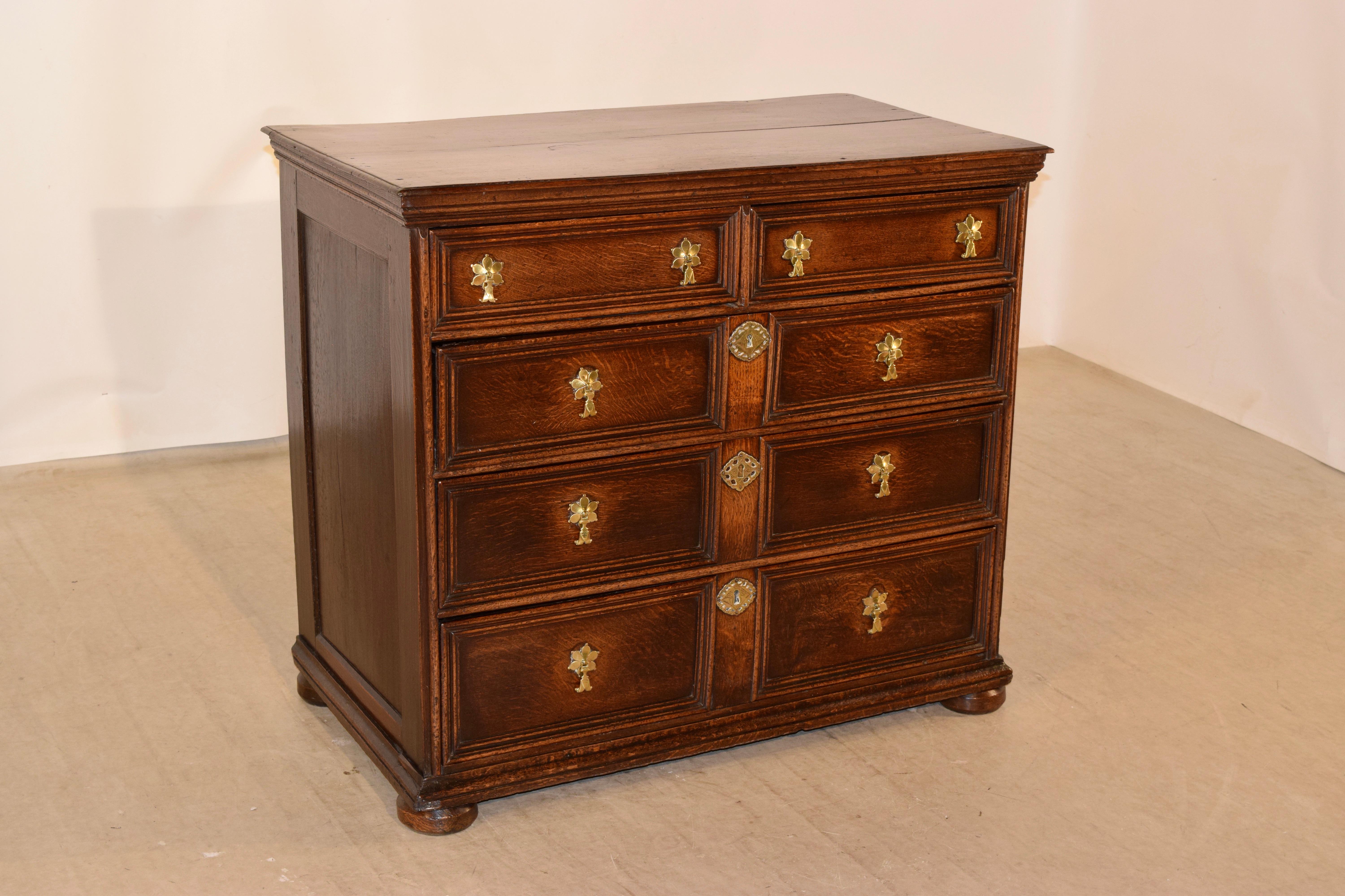 Oak paneled chest of drawers from England, circa 1740-1760. The top has a beveled edge and molded apron with two over three drawers configuration. All of the drawers are paneled with molding and retain what appears to be original hardware. The case